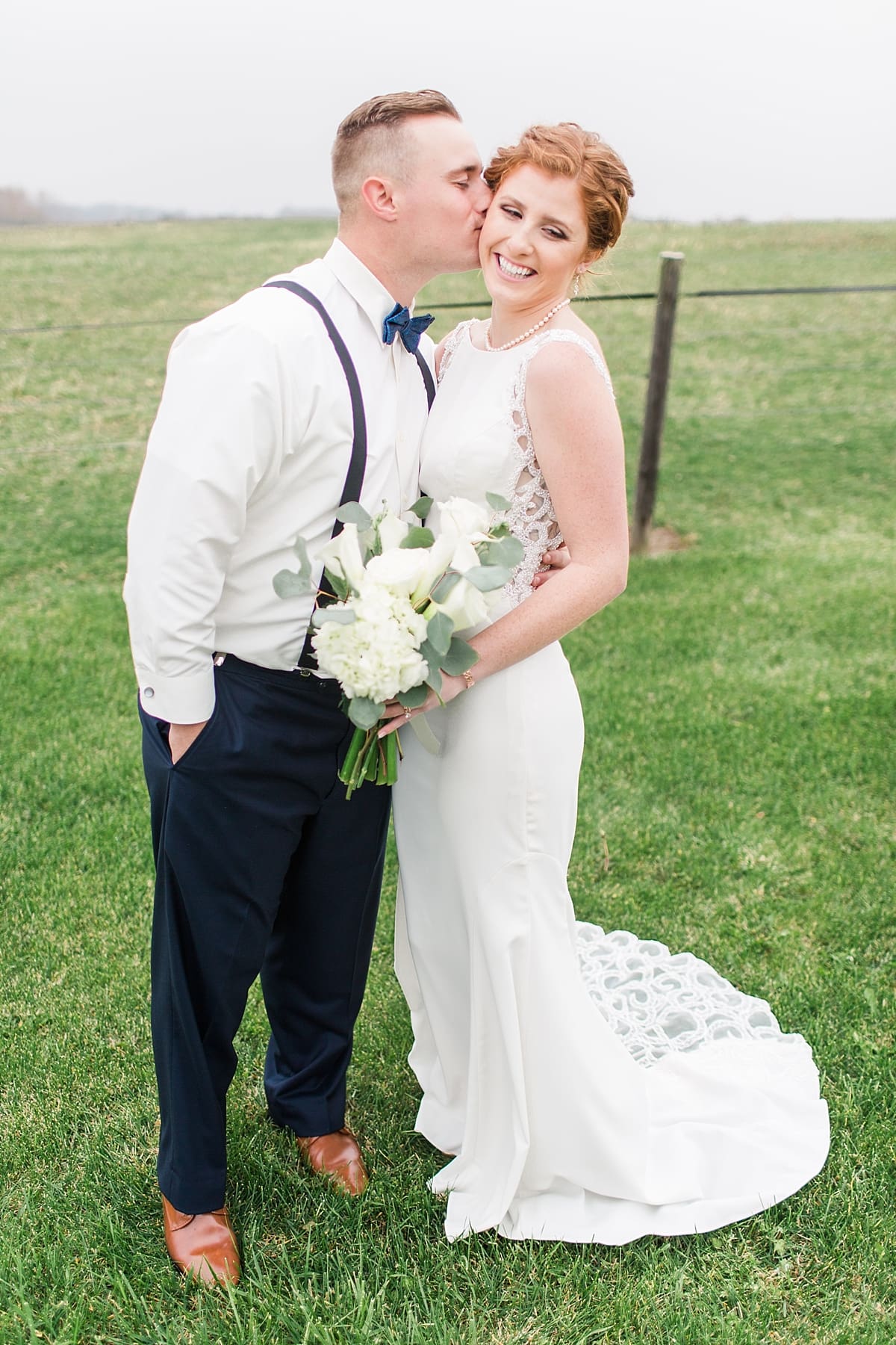 Arielle Peters Photography | Bride and groom kissing in open green field on gloomy wedding day in Huntington, Indiana.