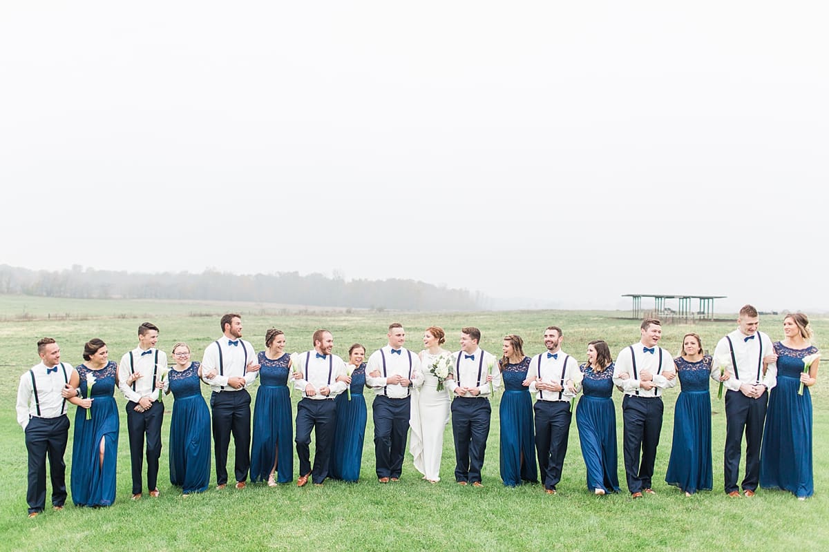 Arielle Peters Photography | Wedding party walking in open green field on gloomy wedding day in Huntington, Indiana.