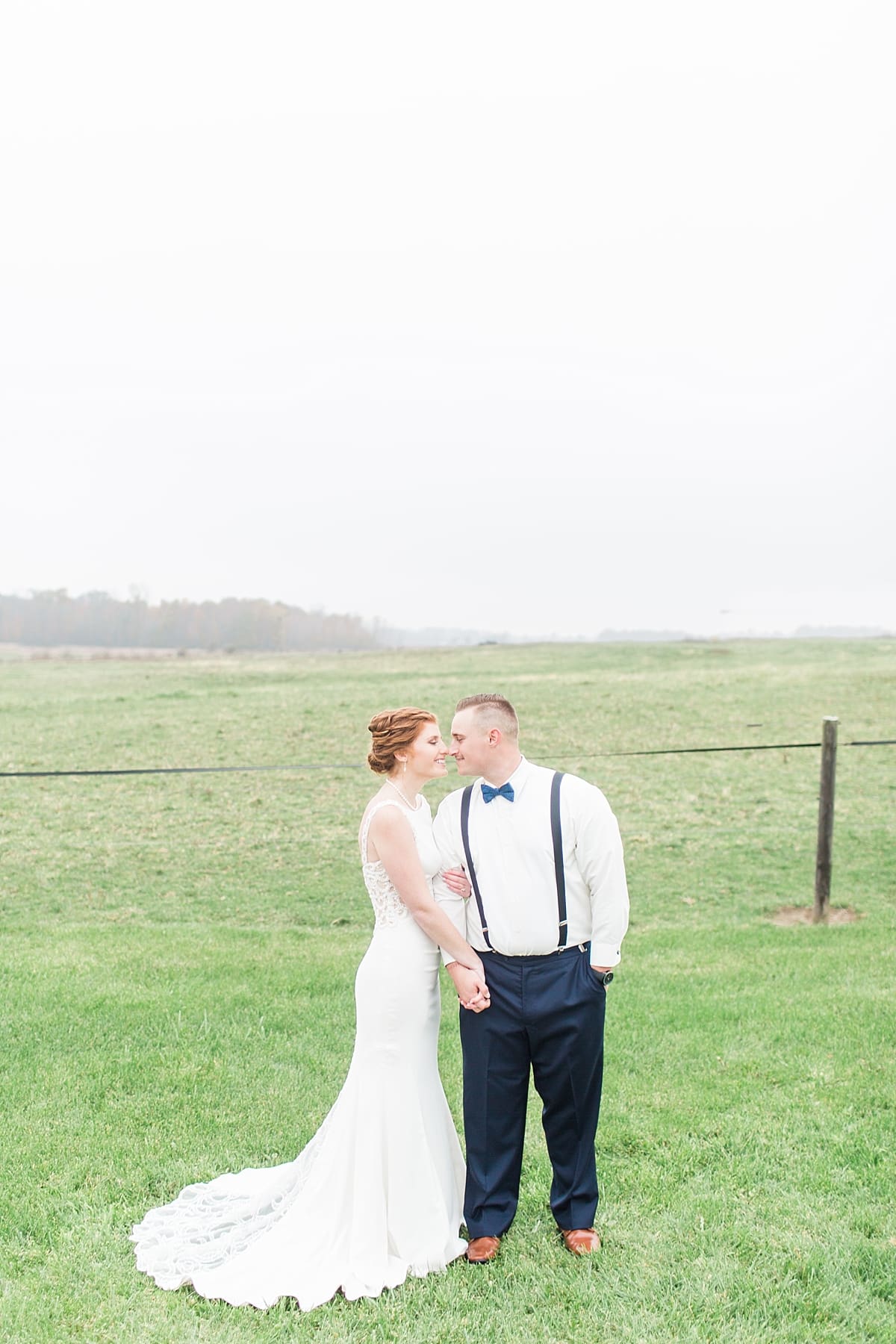 Arielle Peters Photography | Bride and groom smiling at each other in open green field on gloomy wedding day in Huntington, Indiana.