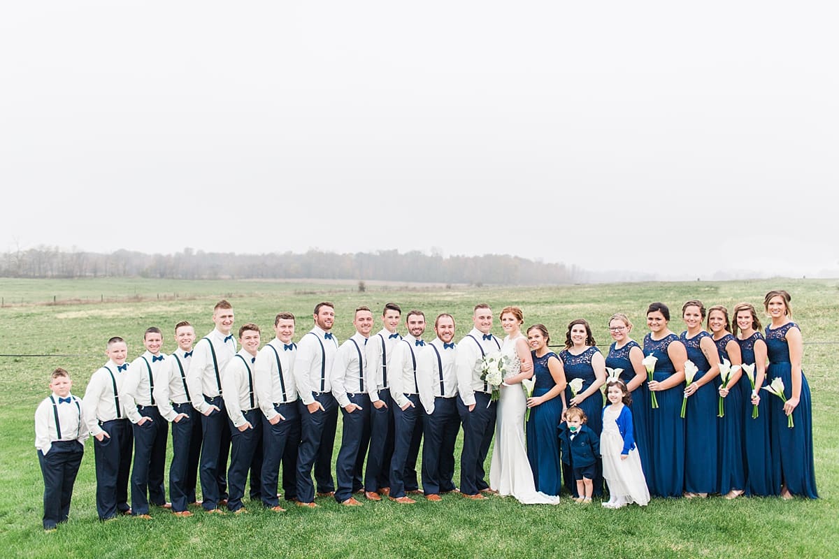 Arielle Peters Photography | Wedding party lined up in open green field on gloomy wedding day in Huntington, Indiana.