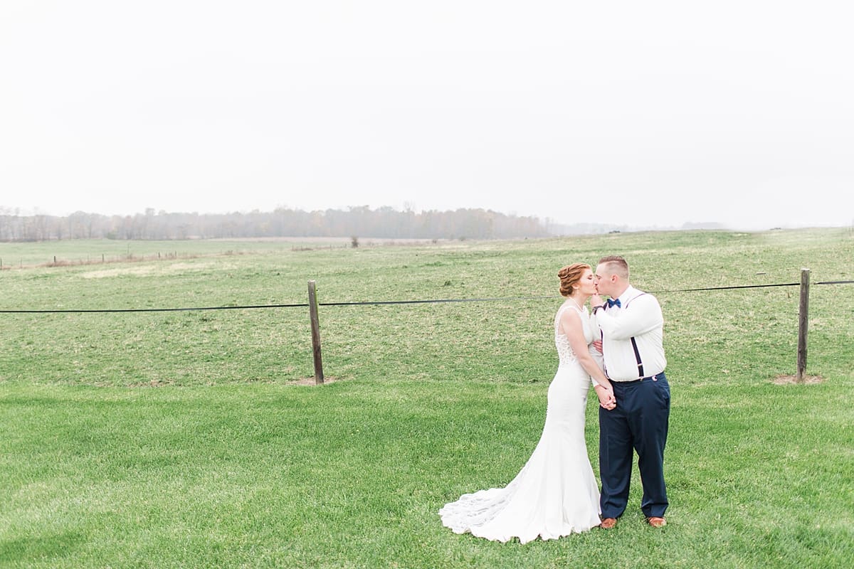 Arielle Peters Photography | Bride and groom kissing in open green field on gloomy wedding day in Huntington, Indiana.