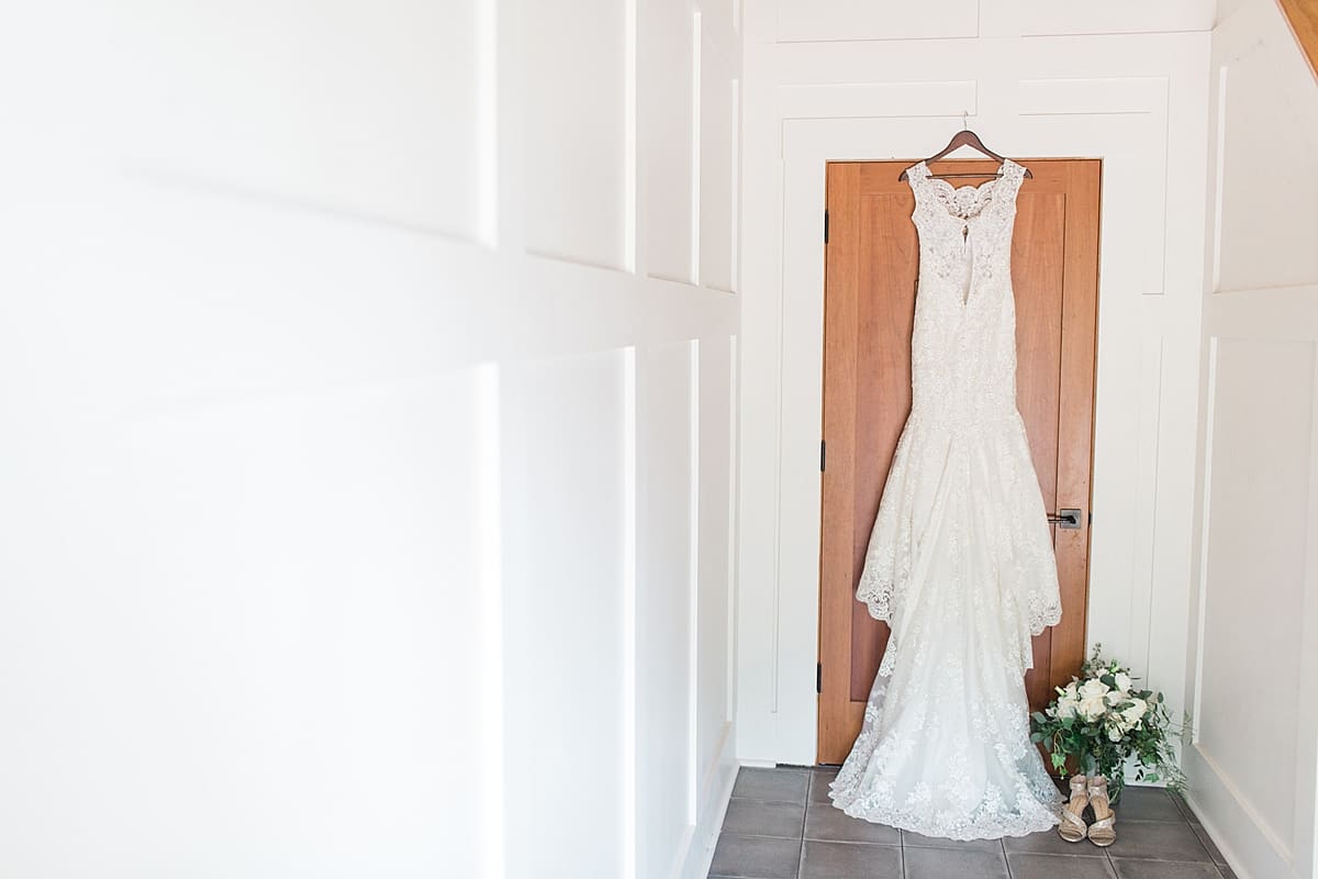 Arielle Peters Photography | Wedding dress hanging in front of wooden door on wedding day.