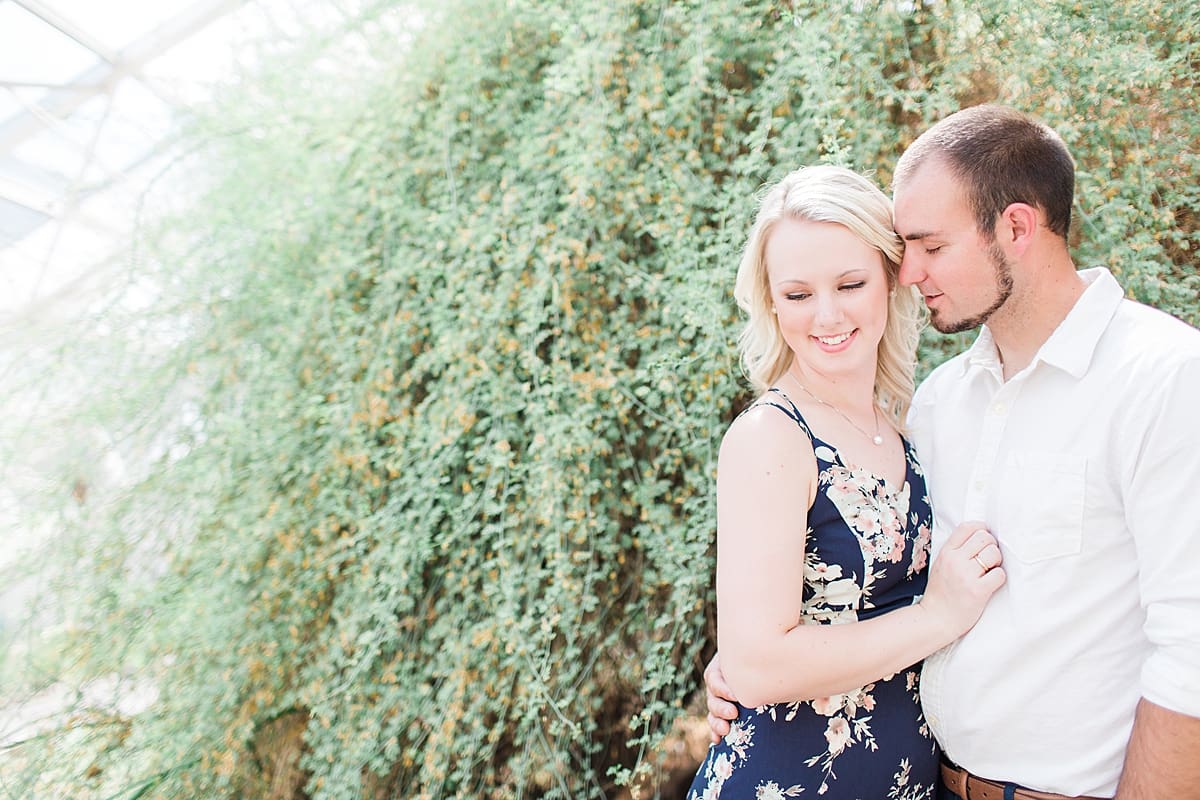 Arielle Peters Photography | Young couple standing next to large ivy-covered wall during summer engagement photos.