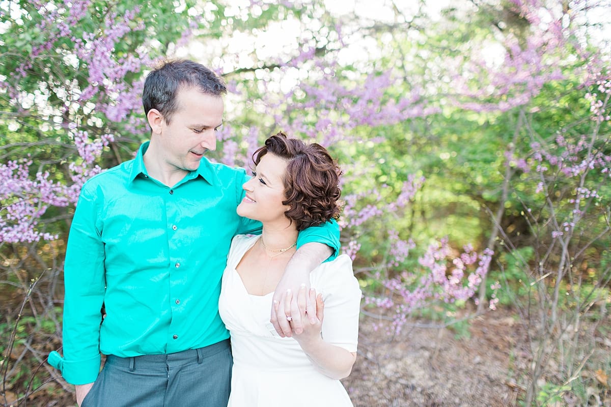 Arielle Peters Photography | Couple taking engagement photos in front of purple blossom trees.