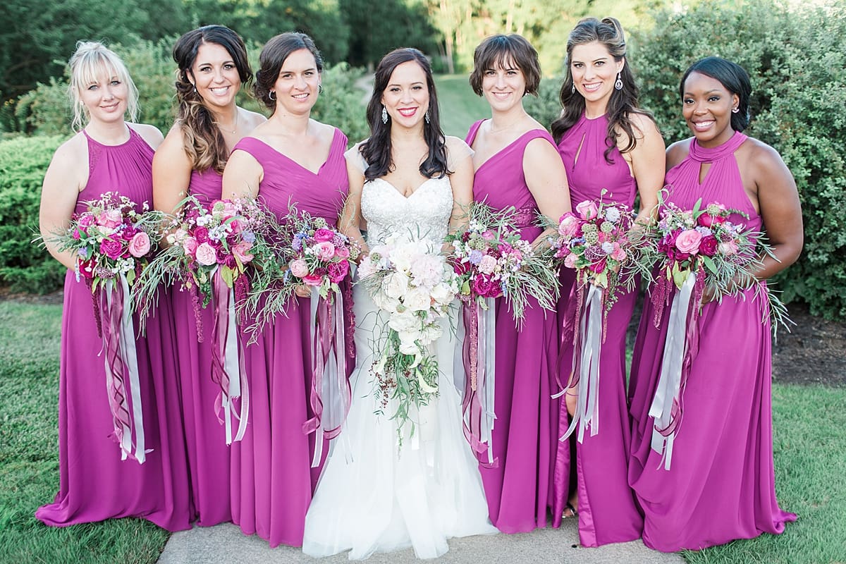 Arielle Peters Photography | Bride and bridesmaids holding bouquets on garden path on wedding day.