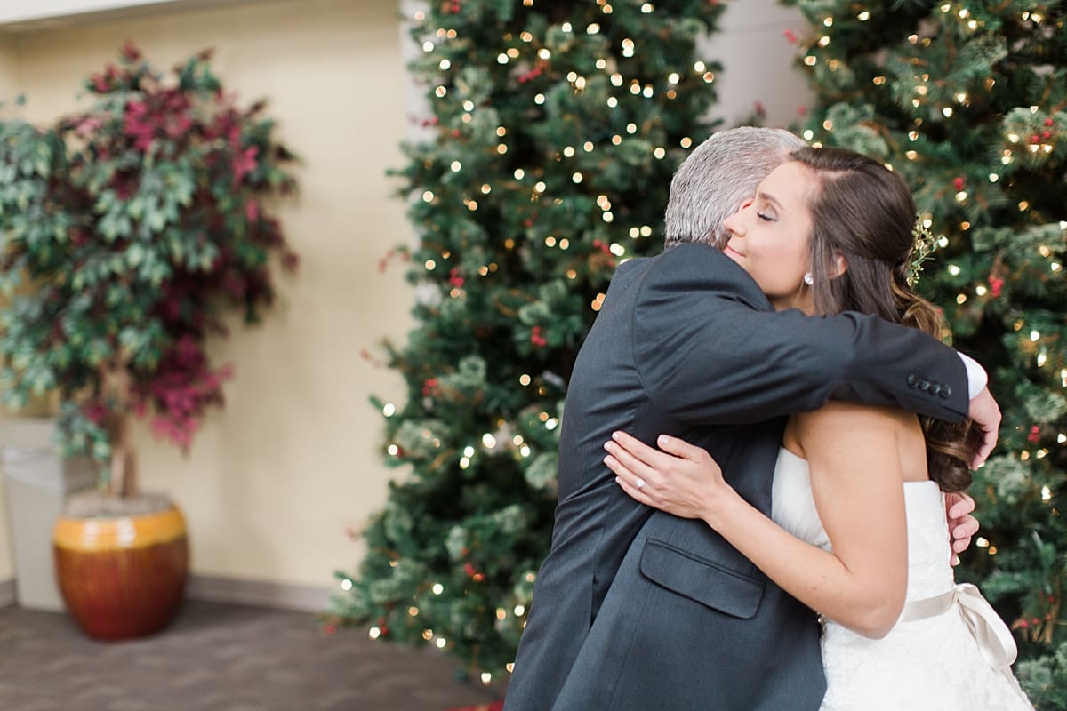 Arielle Peters Photography | Father of bride and bride hugging next to Christmas tree on winter wedding day in Goshen, Indiana.
