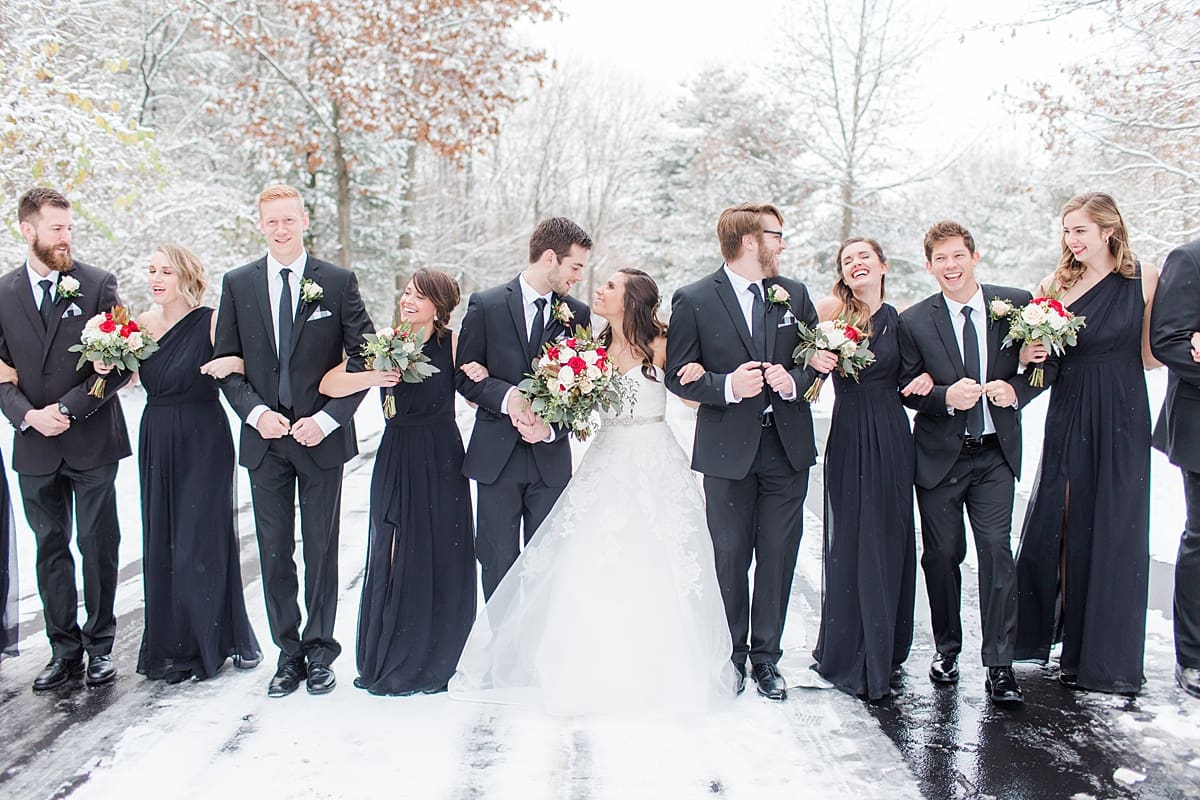 Arielle Peters Photography | Wedding party walking outside on snowy streets on winter wedding day in Goshen, Indiana.