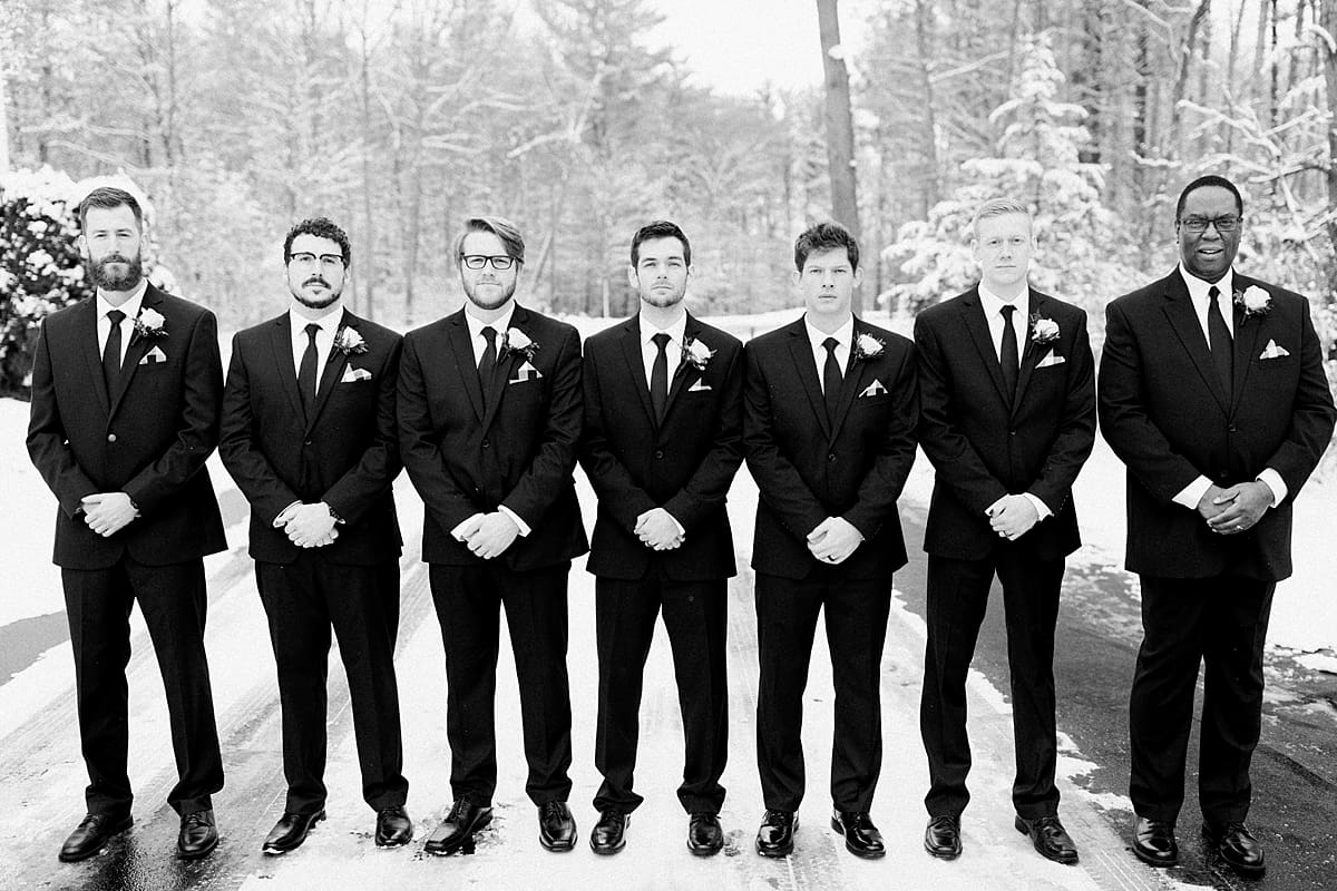 Arielle Peters Photography | Groom and groomsmen standing on snowy street on winter wedding day in Goshen, Indiana.