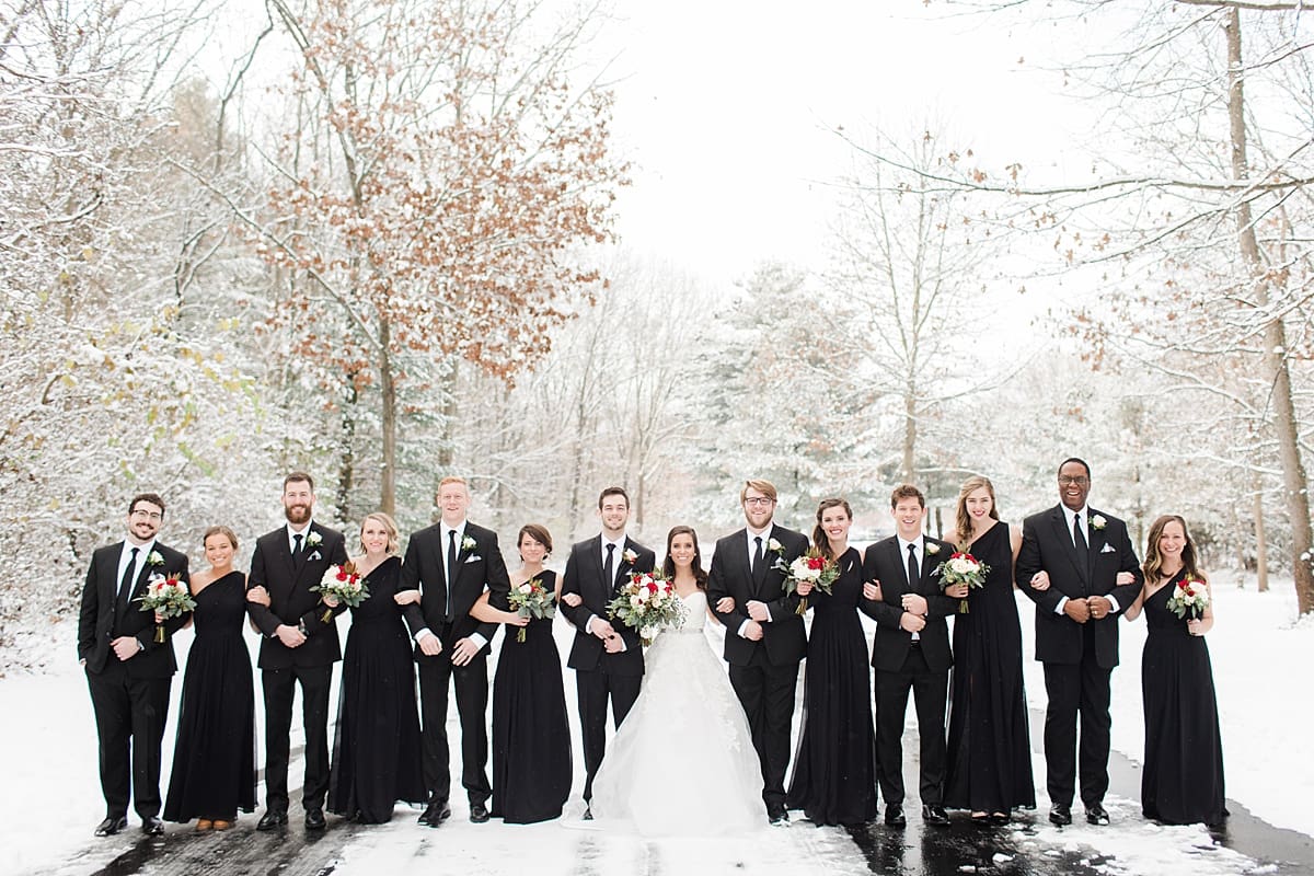 Arielle Peters Photography | Wedding party standing on snowy streets on winter wedding day in Goshen, Indiana.