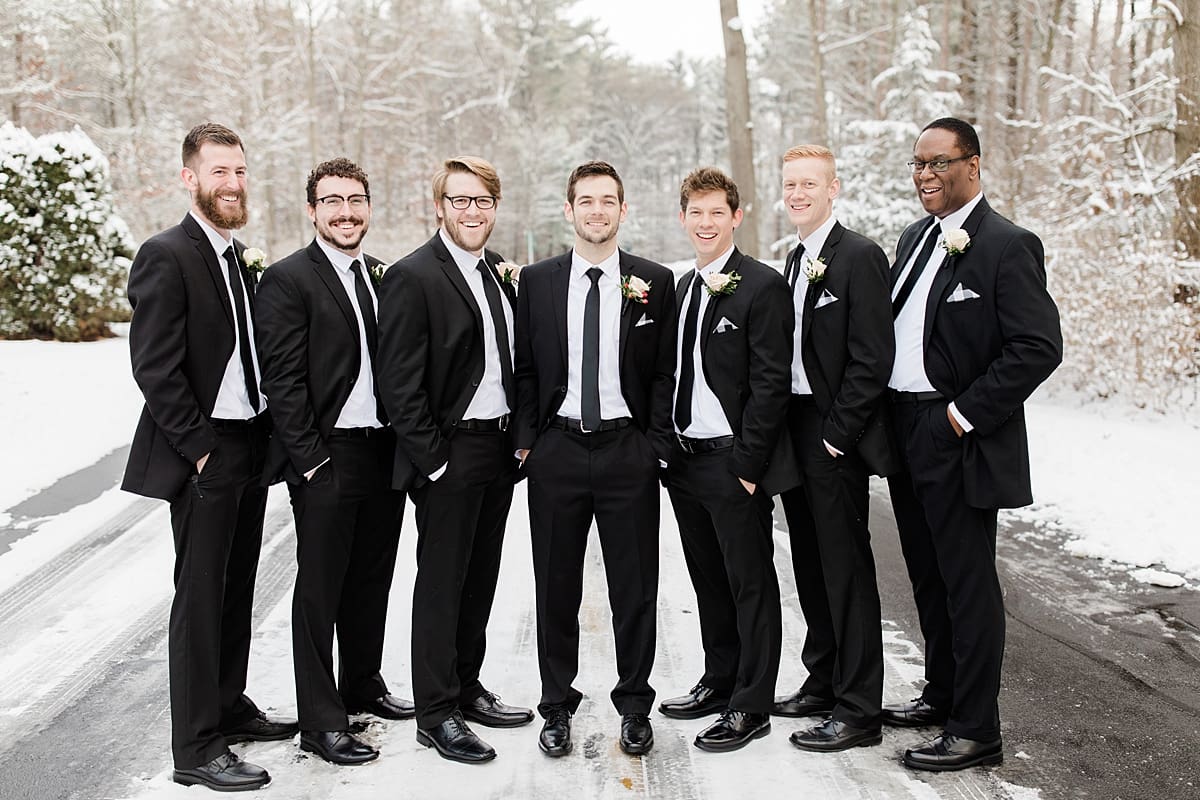 Arielle Peters Photography | Groom and groomsmen standing on snowy streets on winter wedding day in Goshen, Indiana.