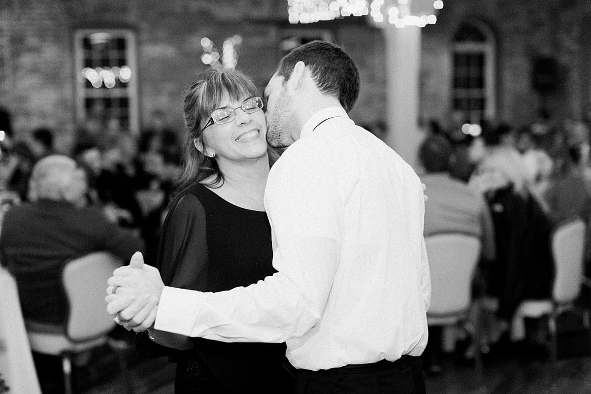 Arielle Peters Photography | Mother of groom and groom sharing a dance at wedding reception on winter wedding day in Goshen, Indiana.
