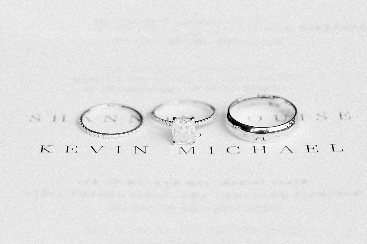 Arielle Peters Photography | Wedding rings on invitation on wedding day inside the Basilica of the Sacred Heart in Notre Dame, Indiana.