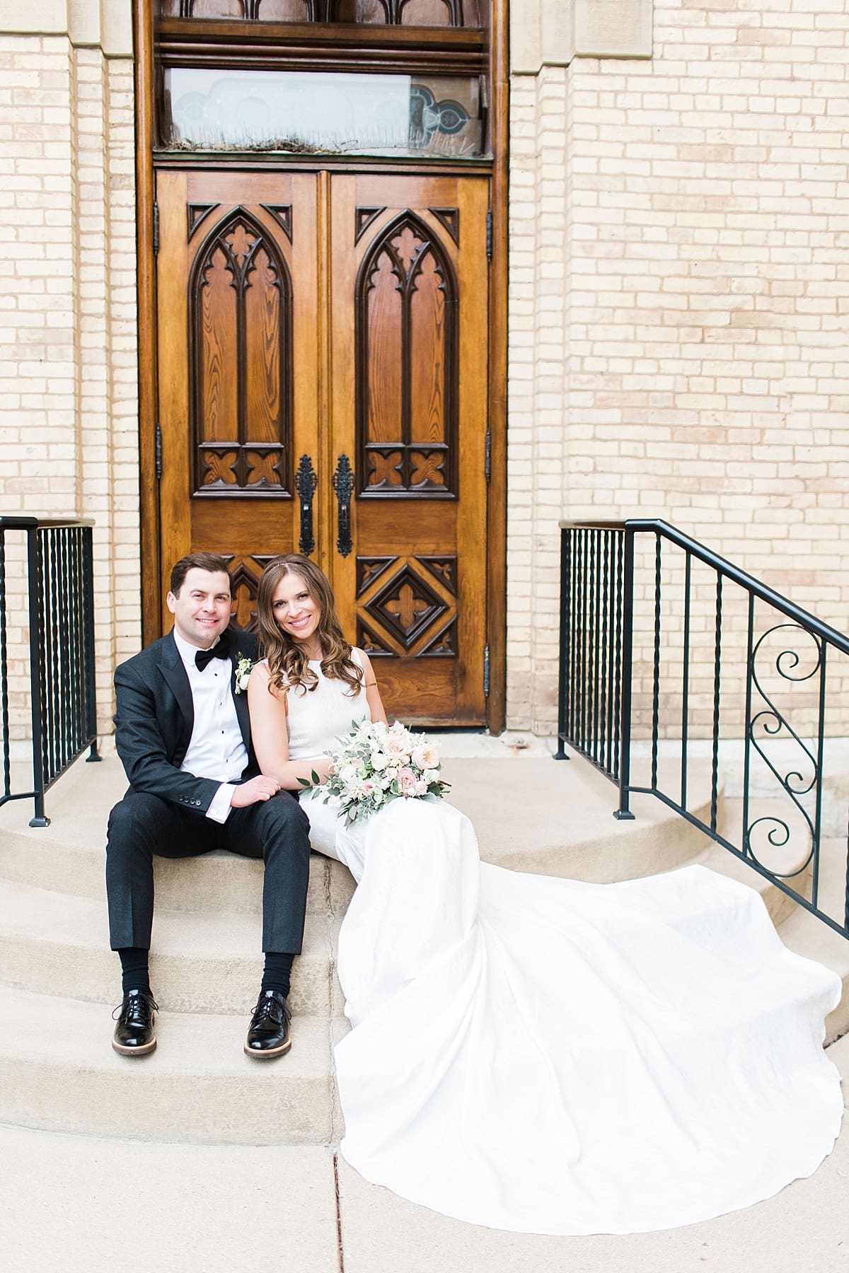 Arielle Peters Photography | Bride and groom sitting in front of cathedral doors on wedding day at the Basilica of the Sacred Heart in Notre Dame, Indiana.