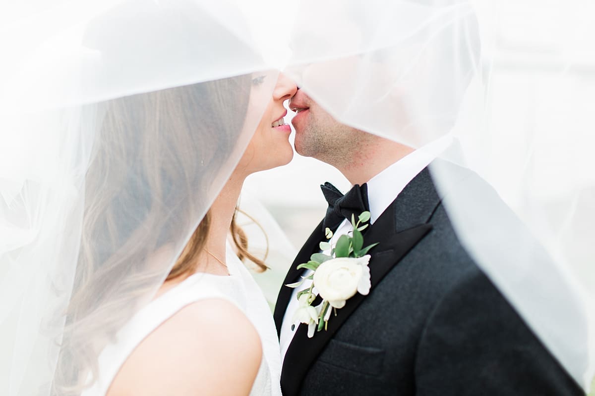 Arielle Peters Photography | Bride and groom kissing under veil on wedding day at St. Joseph's Farm in Granger, Indiana.