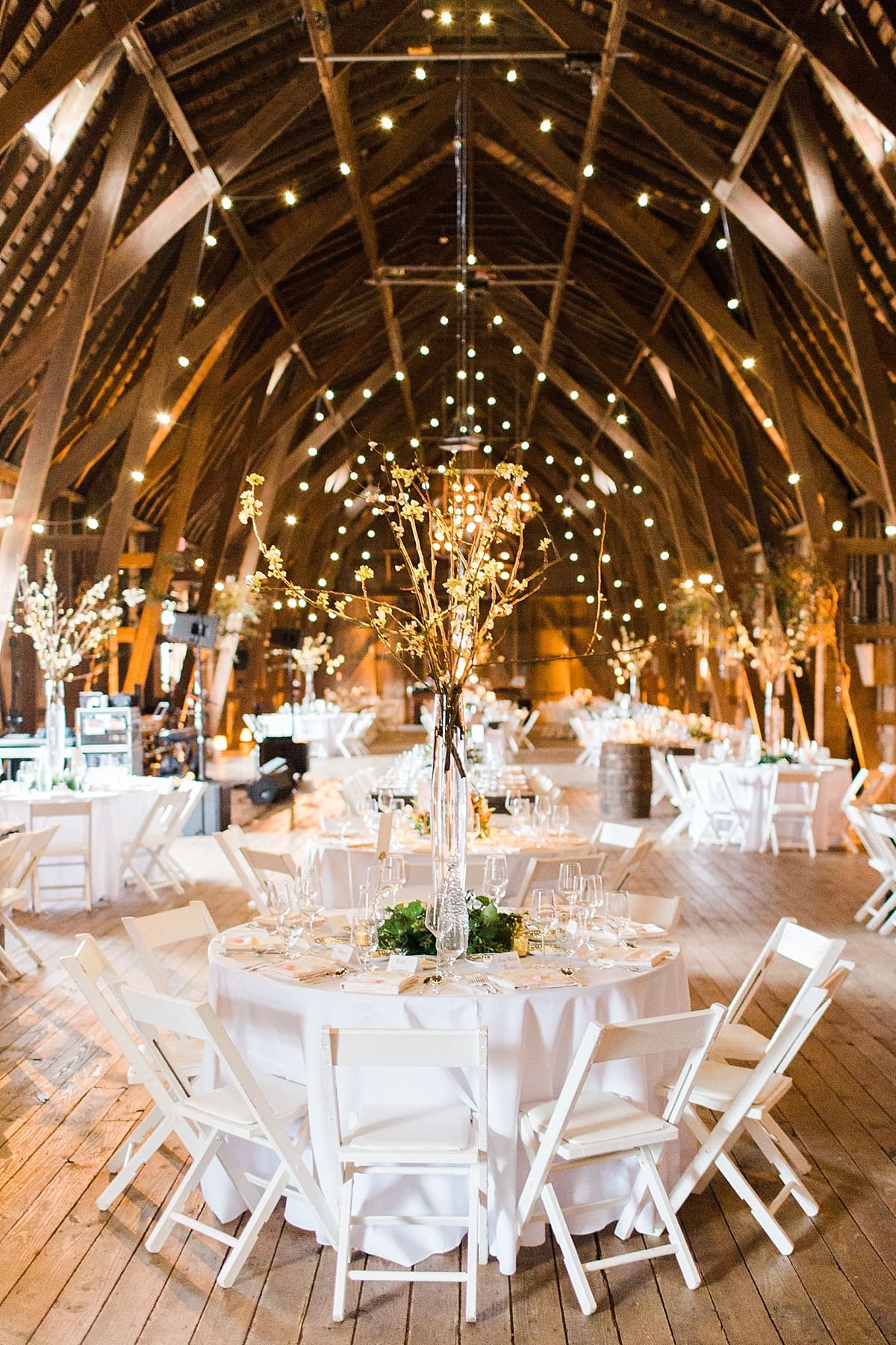 Arielle Peters Photography | Barn wedding reception table settings and floral arrangements on wedding day at St. Joseph's Farm in Granger, Indiana.