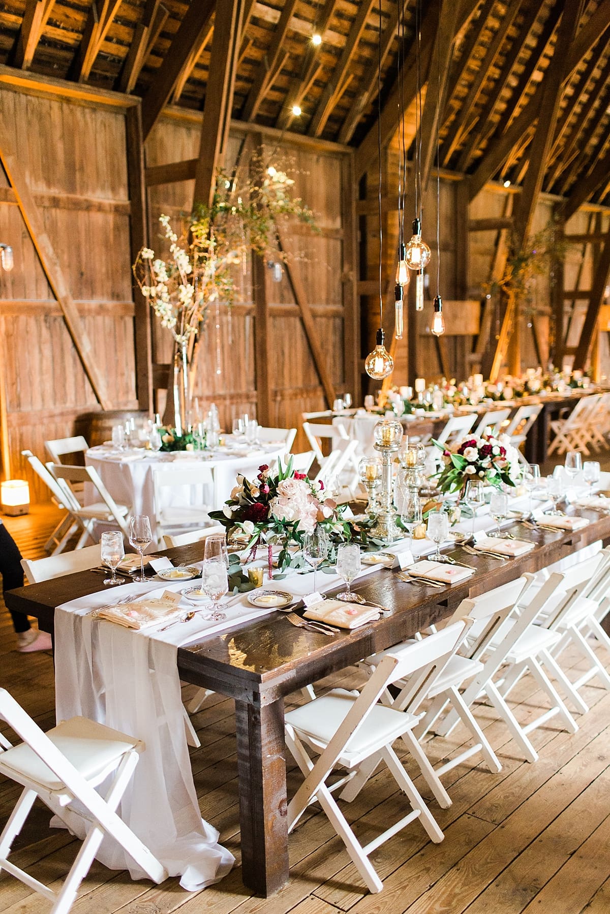 Arielle Peters Photography | Barn wedding reception table settings and floral arrangements on wedding day at St. Joseph's Farm in Granger, Indiana.