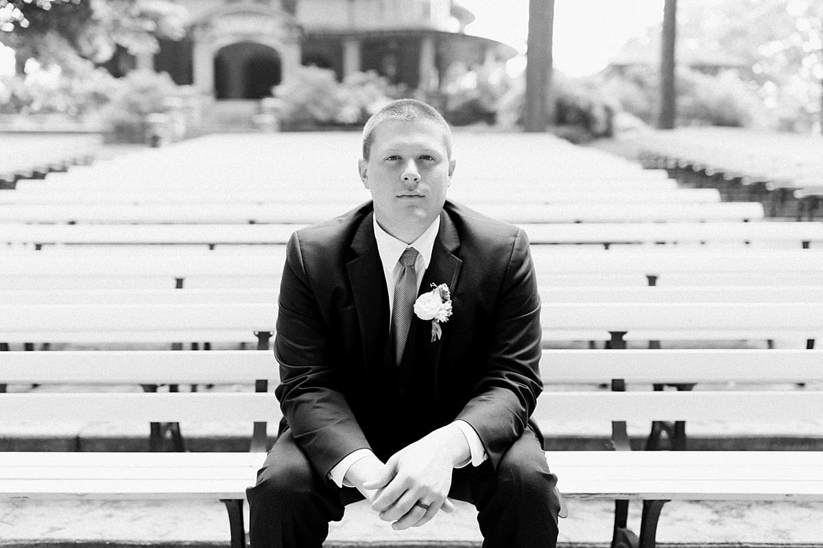 Arielle Peters Photography | Groom sitting outside on benches on wedding day in Winona Lake, Indiana. 