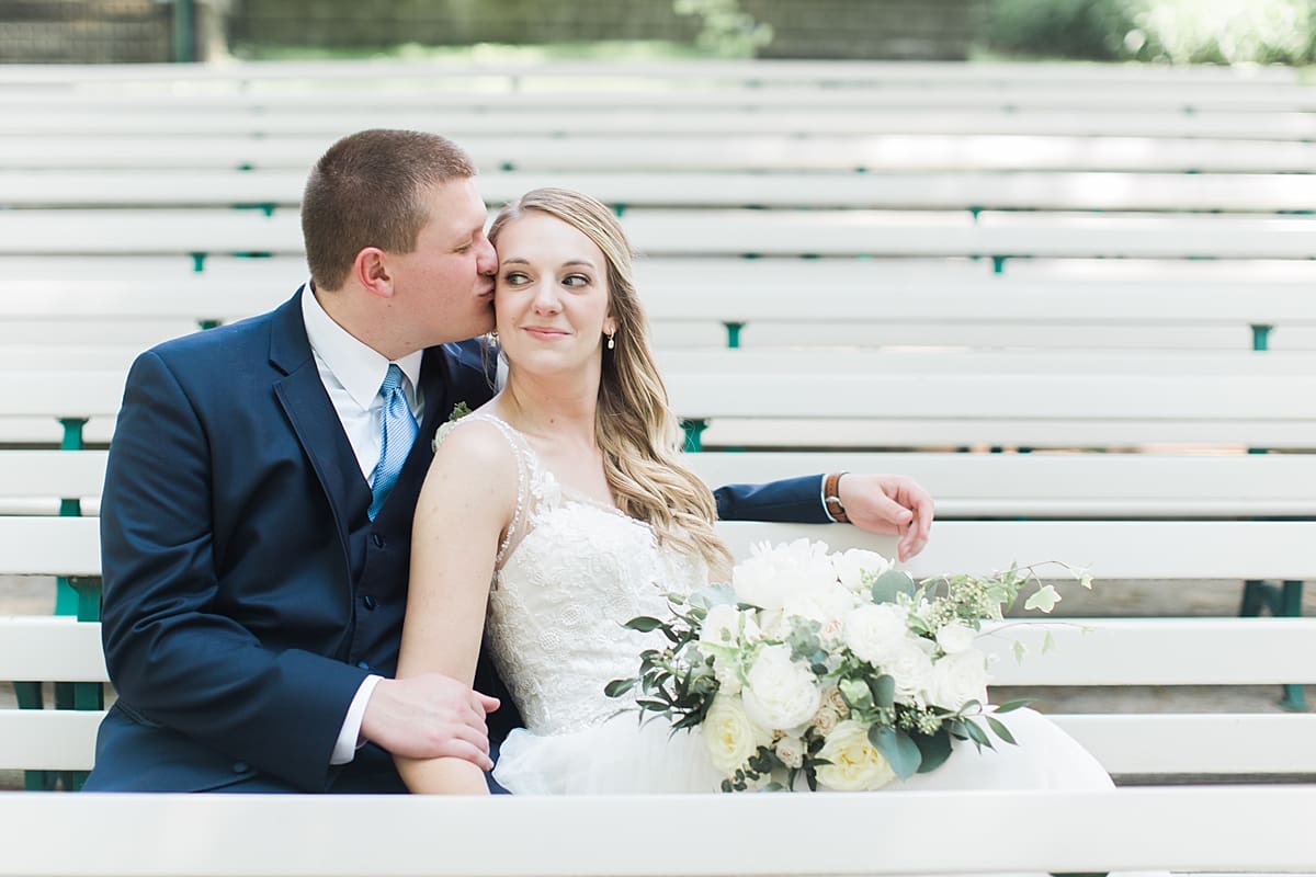Arielle Peters Photography | Bride and groom kissing on bench on wedding day in Winona Lake, Indiana. 