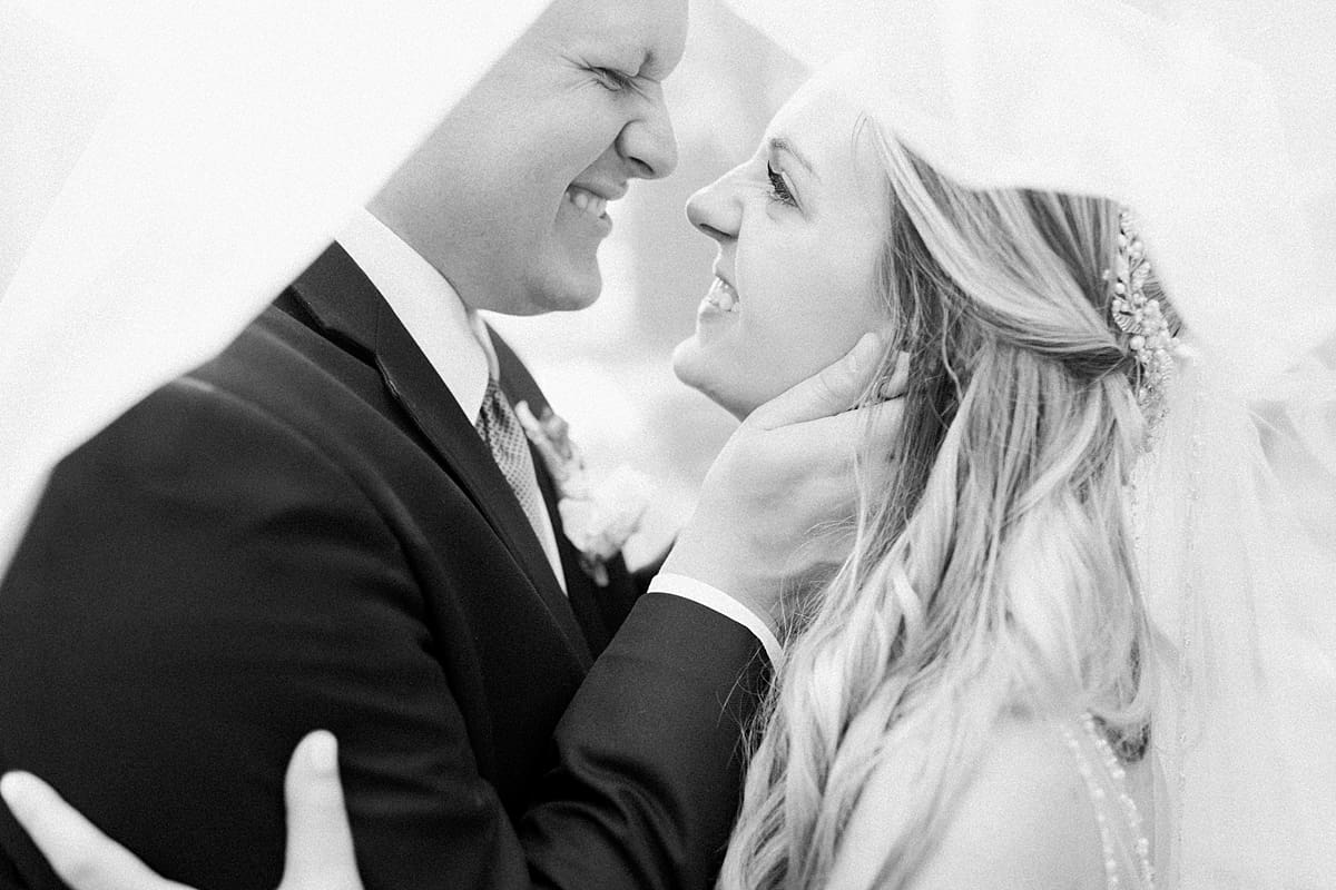 Arielle Peters Photography | Bride and groom smiling under veil on wedding day at Bread & Chocolate in Goshen, Indiana.