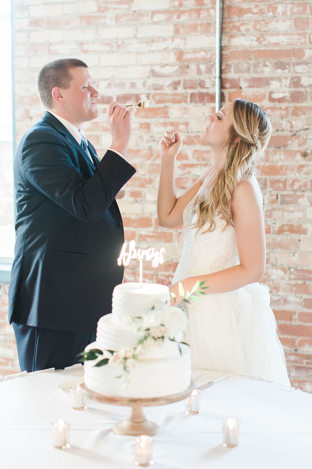 Arielle Peters Photography | Bride and groom feeding each other cake at wedding reception on wedding day at Bread & Chocolate in Goshen, Indiana.