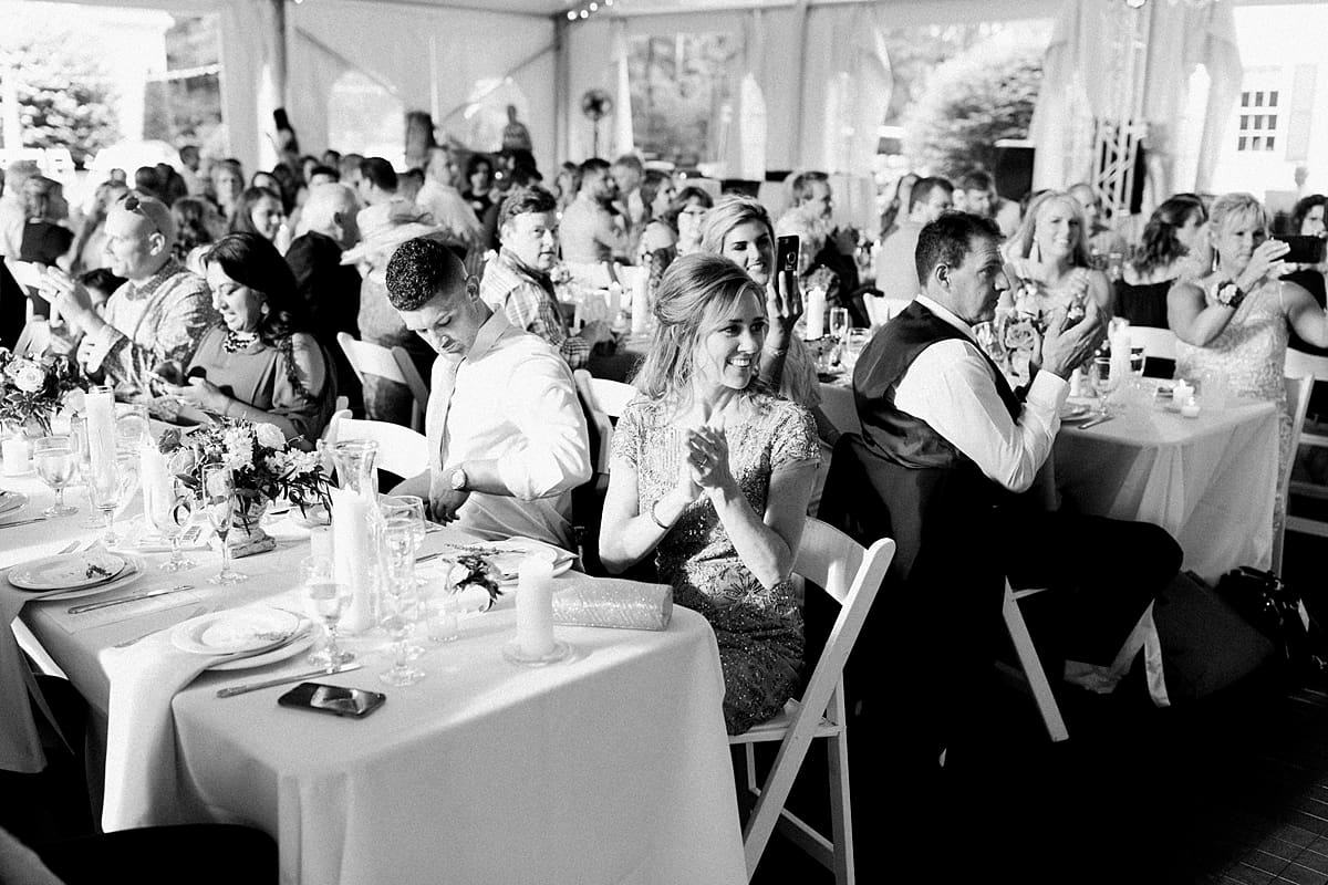  Arielle Peters Photography | Wedding guests clapping inside outdoor tent wedding reception at The Morris Estate in Niles, Michigan.