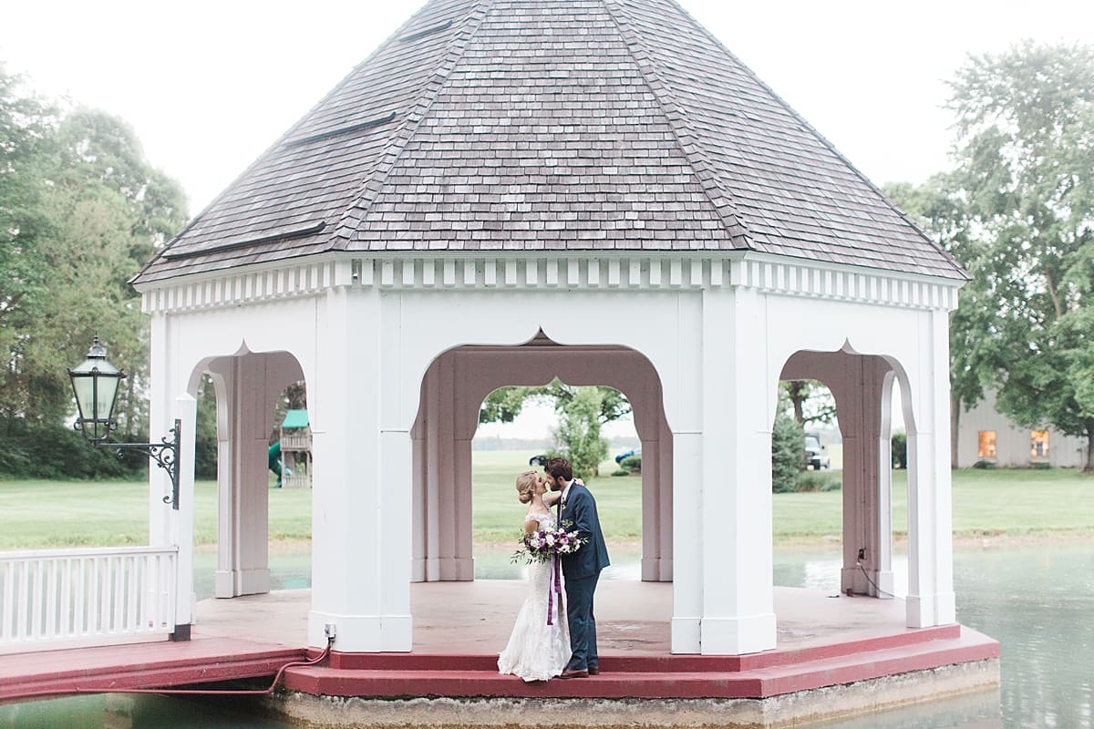  Arielle Peters Photography | Bride and groom kissing under gazebo on water on wedding day at The Morris Estate in Niles, Michigan.