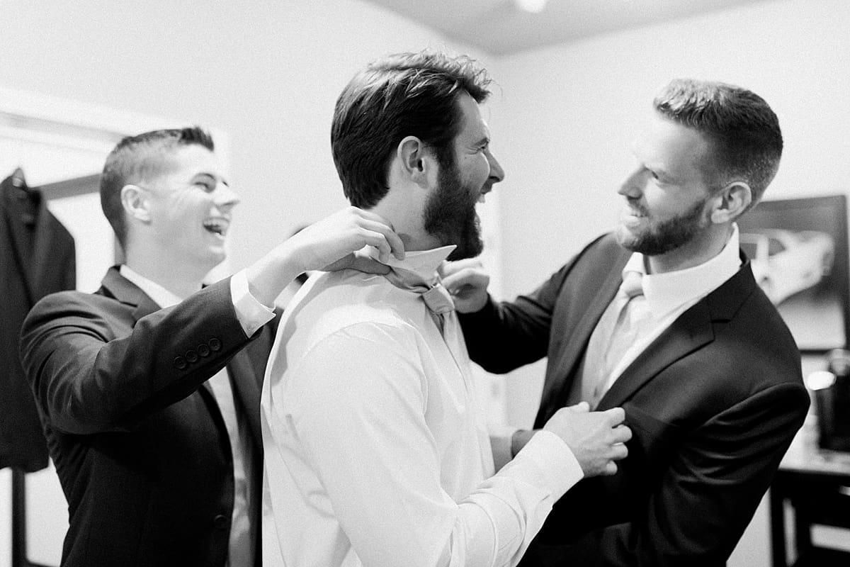  Arielle Peters Photography | Groomsmen helping groom get ready on wedding day at The Morris Estate in Niles, Michigan.