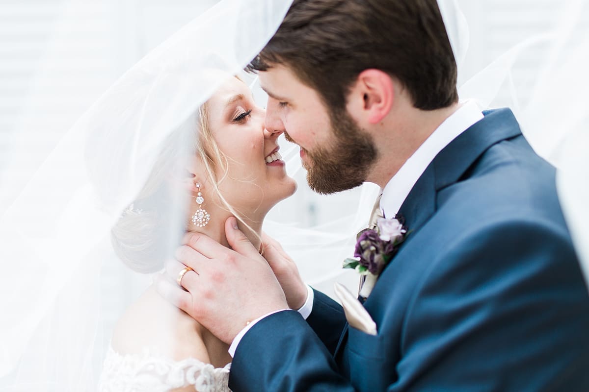  Arielle Peters Photography | Bride and groom kissing under veil on wedding day at The Morris Estate in Niles, Michigan.