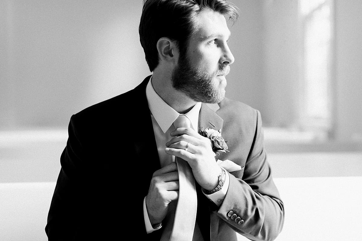  Arielle Peters Photography | Groom adjusting tie inside church on wedding day at The Morris Estate in Niles, Michigan.