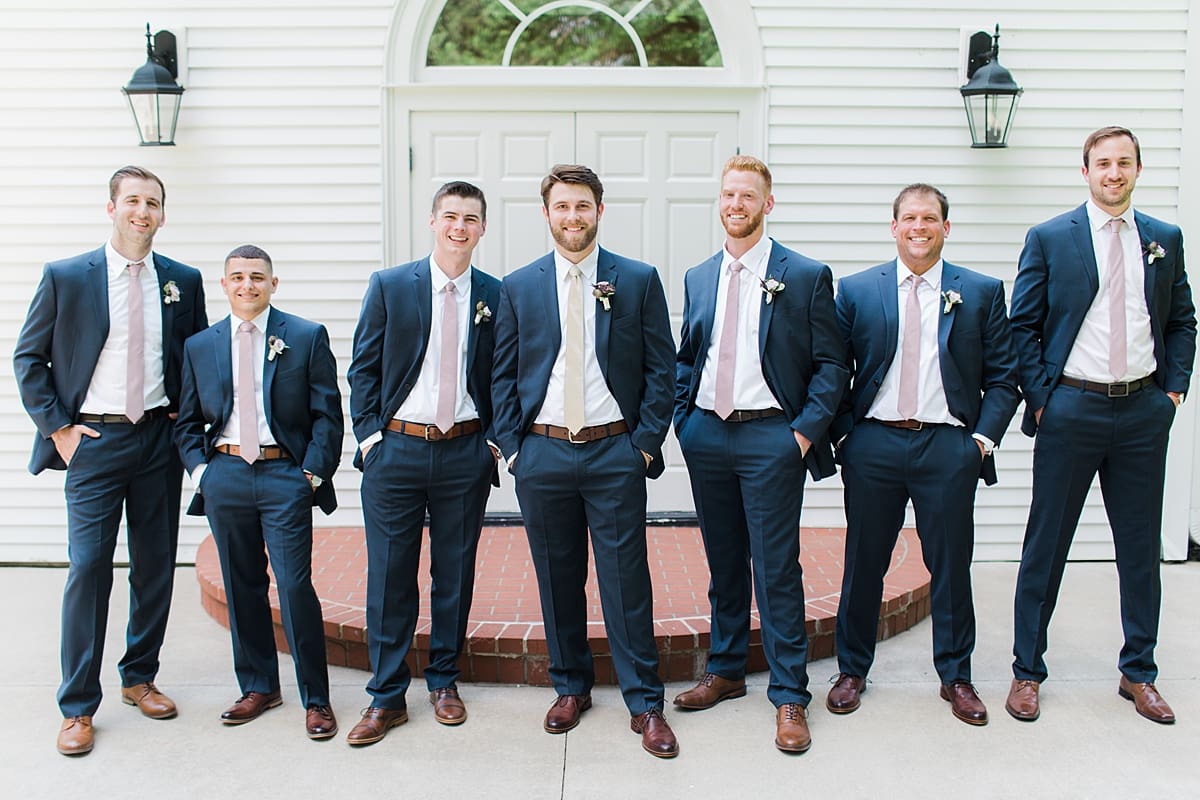  Arielle Peters Photography | Groom and groomsmen standing outside church on wedding day at The Morris Estate in Niles, Michigan.