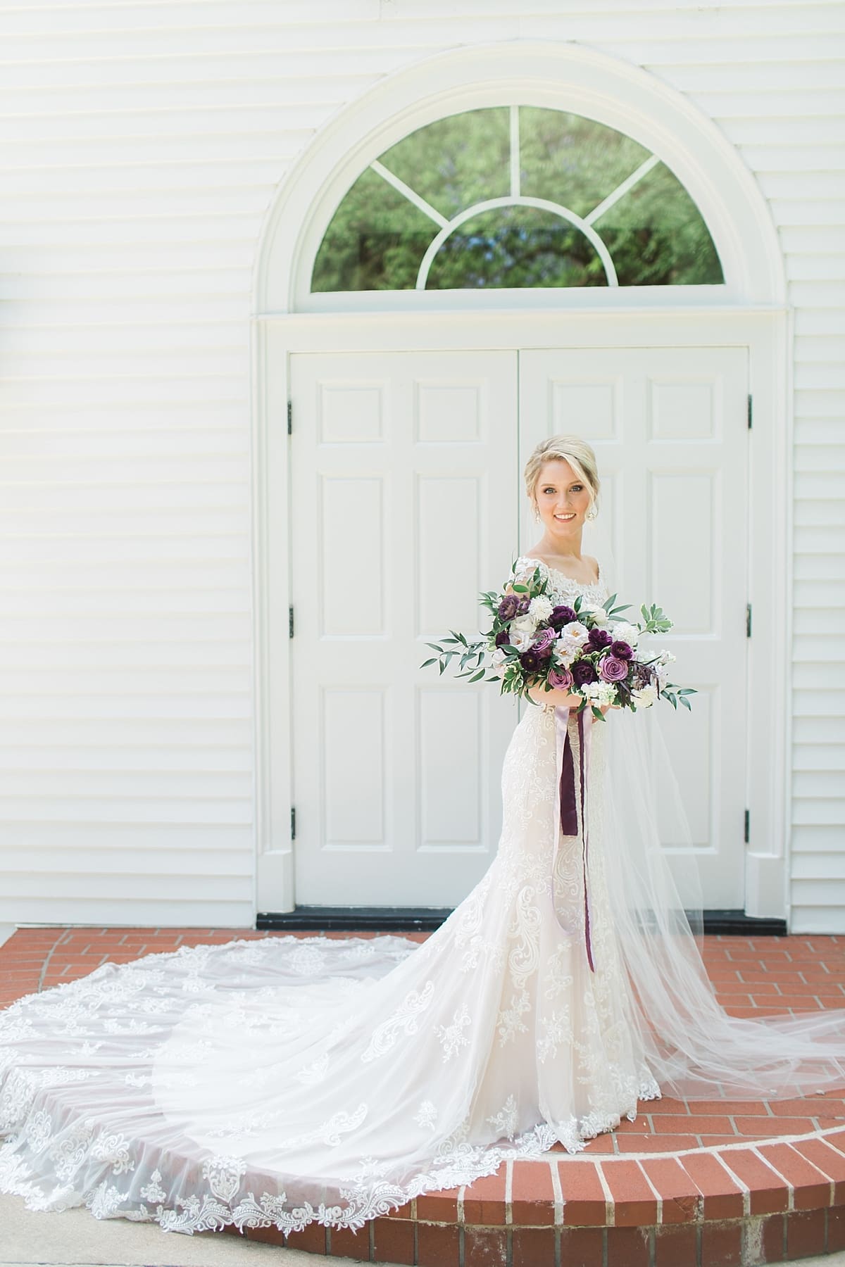  Arielle Peters Photography | Bride holding bouquet in front of church doors on wedding day at The Morris Estate in Niles, Michigan.