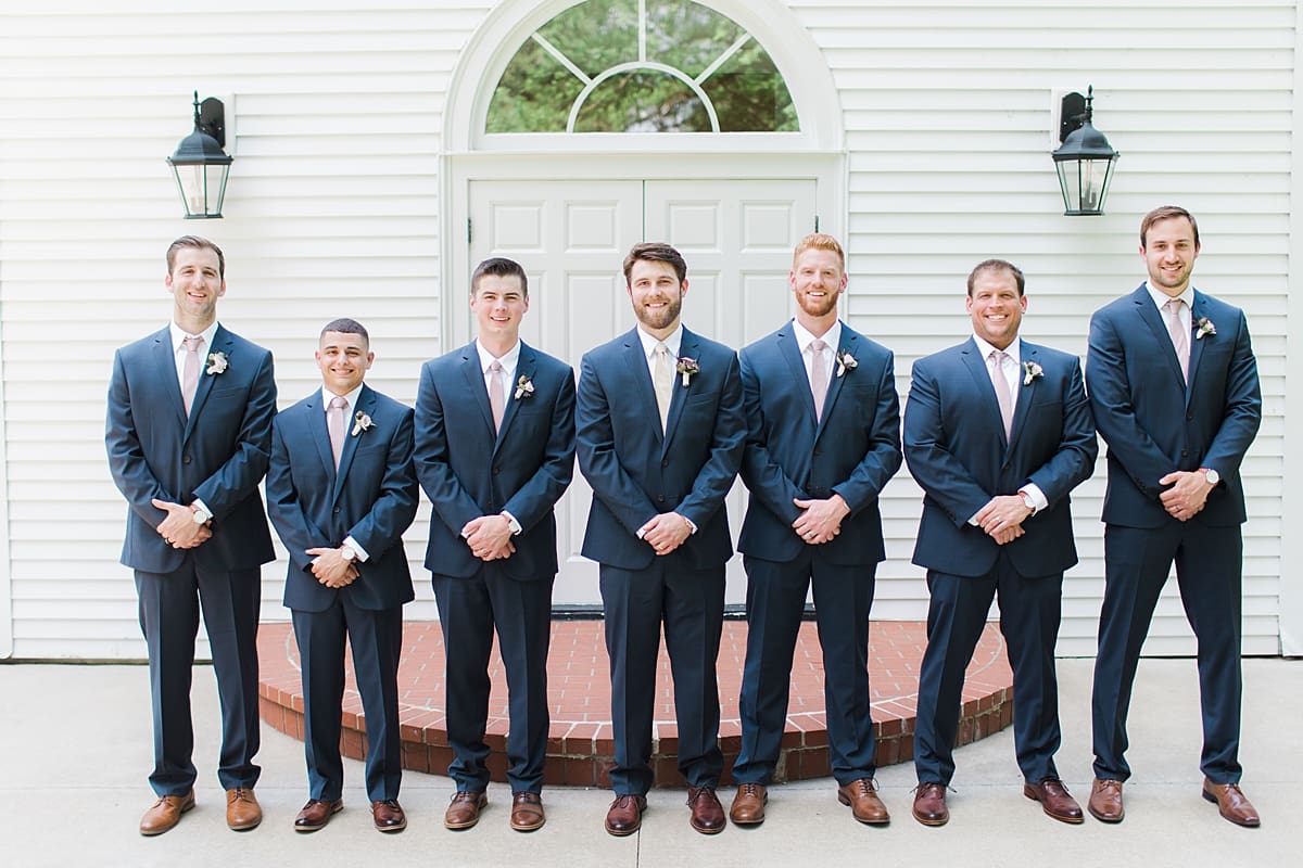  Arielle Peters Photography | Groom and groomsmen in front of church doors on wedding day at The Morris Estate in Niles, Michigan.