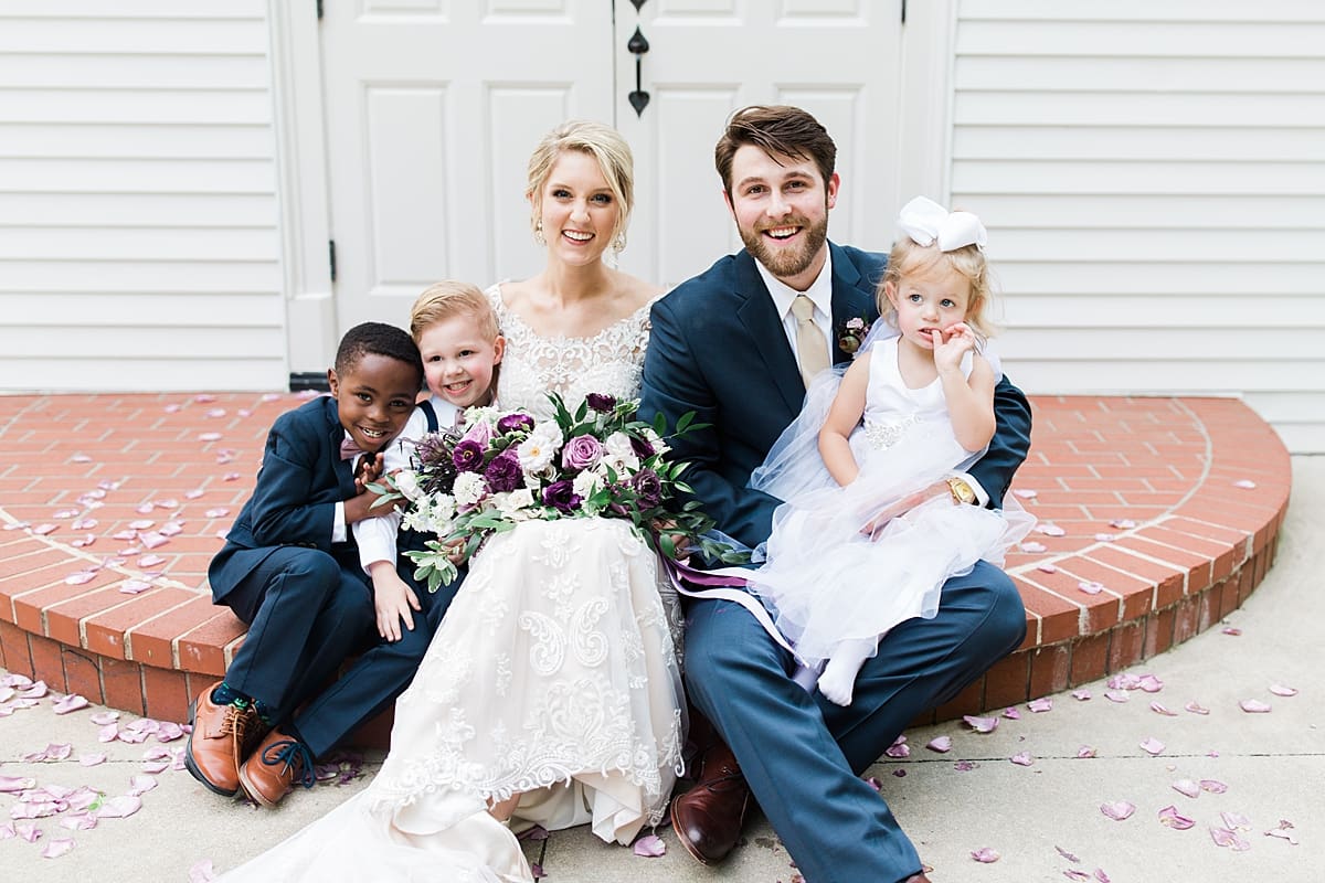  Arielle Peters Photography | Bride and bridesmaids with ring bearers and flower girl in front of church doors on wedding day at The Morris Estate in Niles, Michigan.