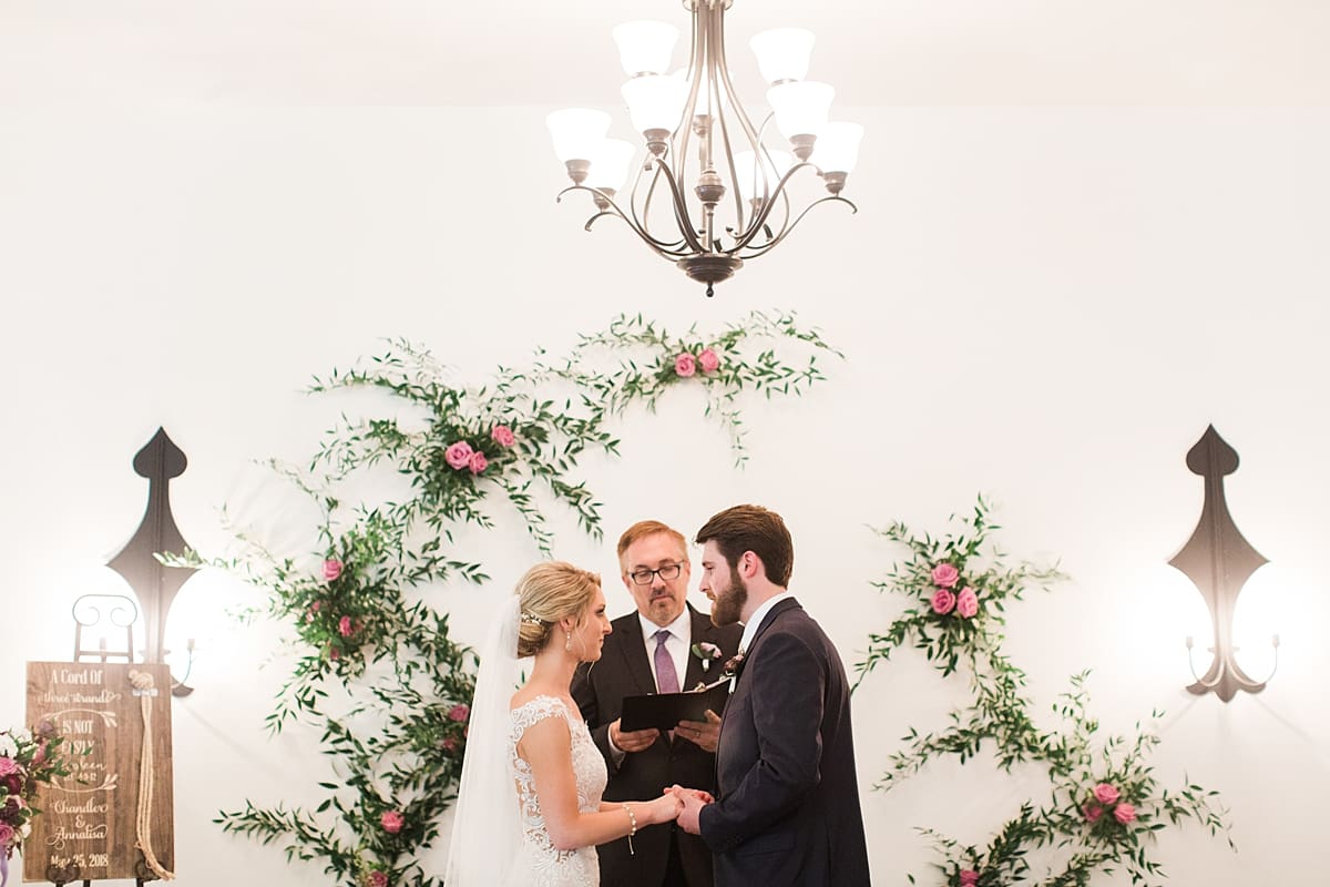  Arielle Peters Photography | Bride and groom holding hands at alter on wedding day at The Morris Estate in Niles, Michigan.