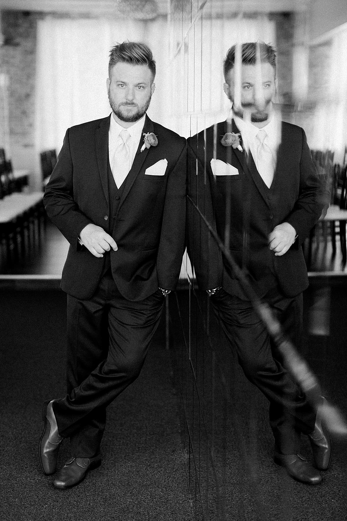 Arielle Peters Photography | Groom in tux next to reflective wall at The Allure in LaPorte, Indiana on wedding day.