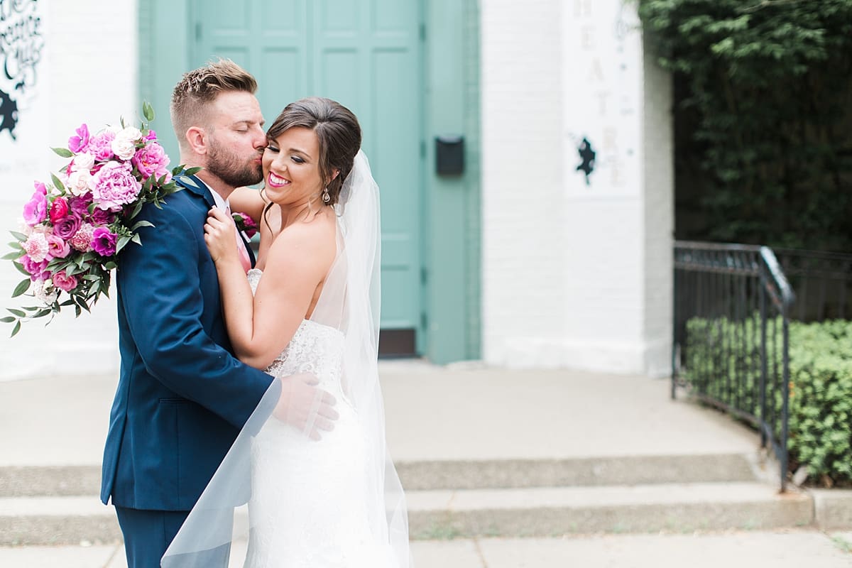 Arielle Peters Photography | Bride and groom kissing in front of turqoise doors at The Allure in LaPorte, Indiana on wedding day.