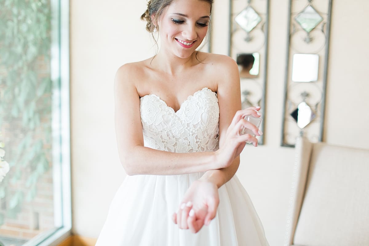 Arielle Peters Photography | Bride putting on perfume on wedding day at Morris Park Country Club in South Bend, Indiana.