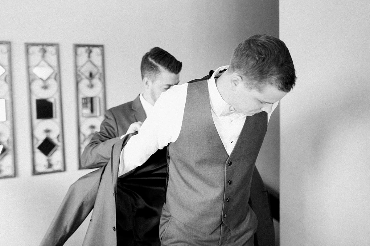 Arielle Peters Photography | Groom putting on tux jacket on wedding day at Morris Park Country Club in South Bend, Indiana.