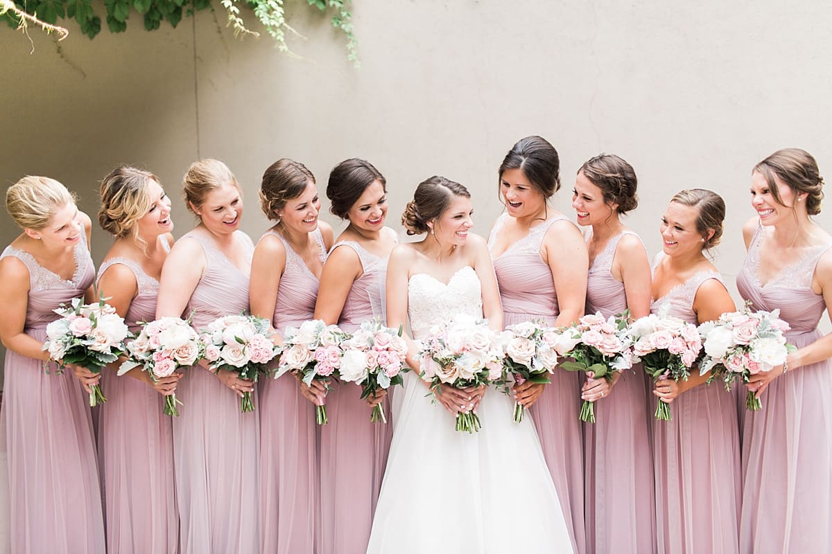 Arielle Peters Photography | Bride and bridesmaids by ivy-covered wall on wedding day at Morris Park Country Club in South Bend, Indiana.