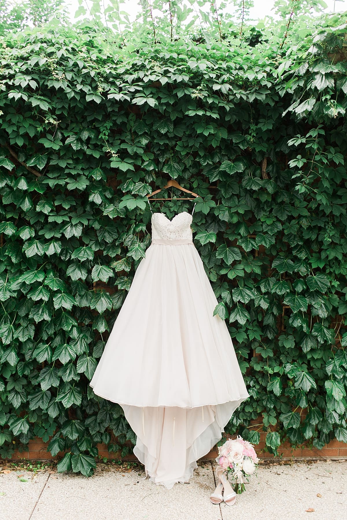 Arielle Peters Photography | Wedding dress hanging on ivy wall on wedding day at Morris Park Country Club in South Bend, Indiana.