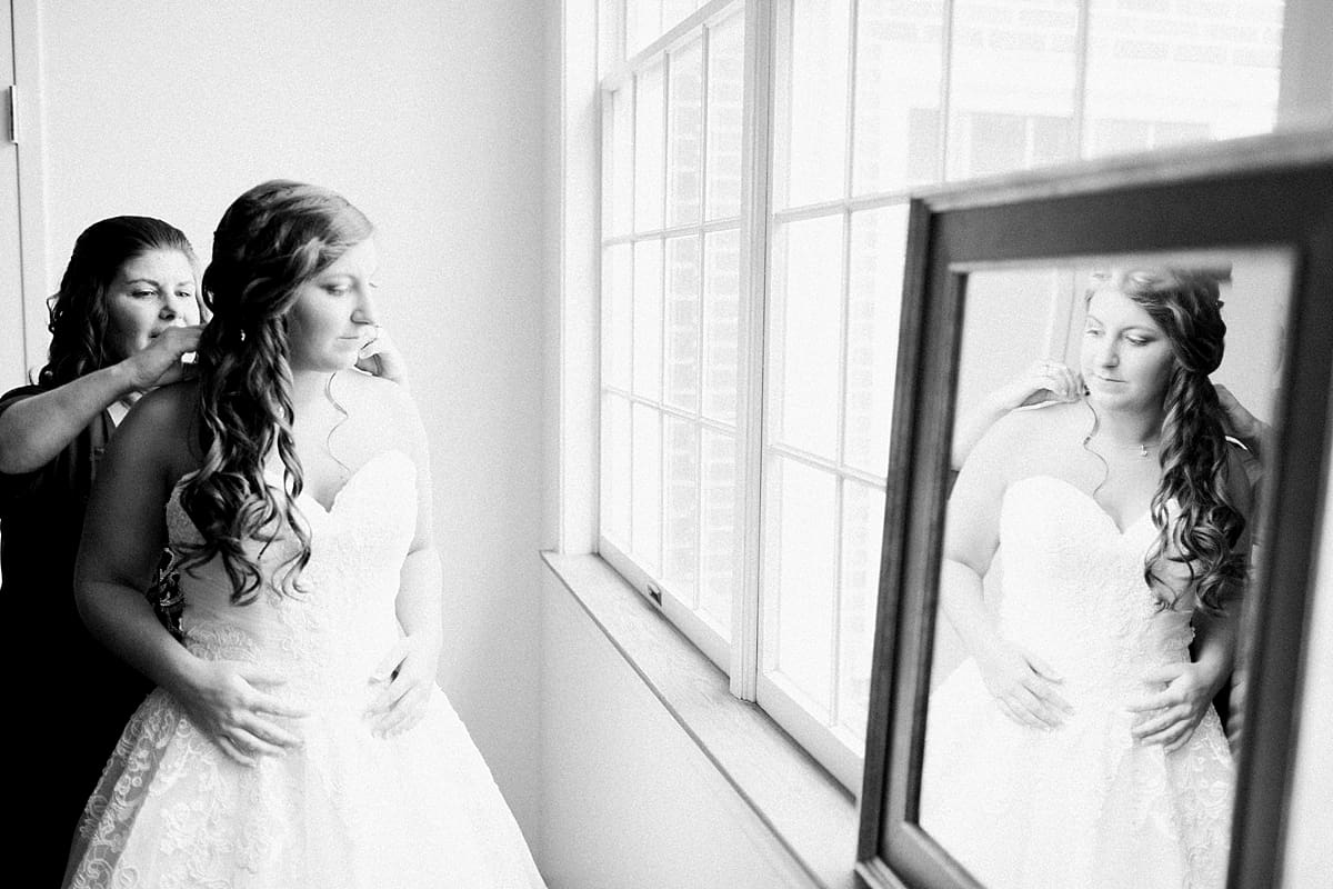 Arielle Peters Photography | Mother of the bride helping bride put on wedding dress on wedding day at Trinity Church in South Bend, Indiana.
