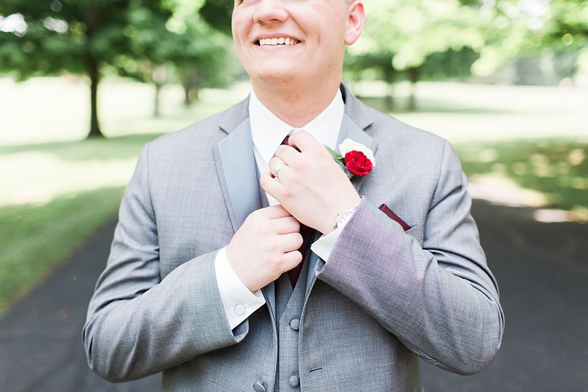 Arielle Peters Photography | Groom adjusting his tie on empty street on wedding day at Trinity Church in South Bend, Indiana.