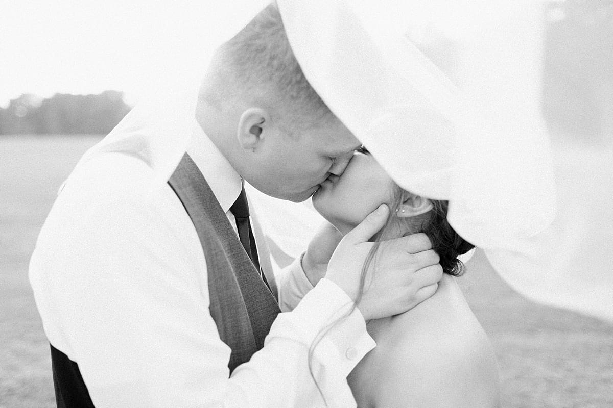 Arielle Peters Photography | Bride and groom kissing under veil on wedding day at Sts. Peter and Paul Social Hall in South Bend, Indiana.