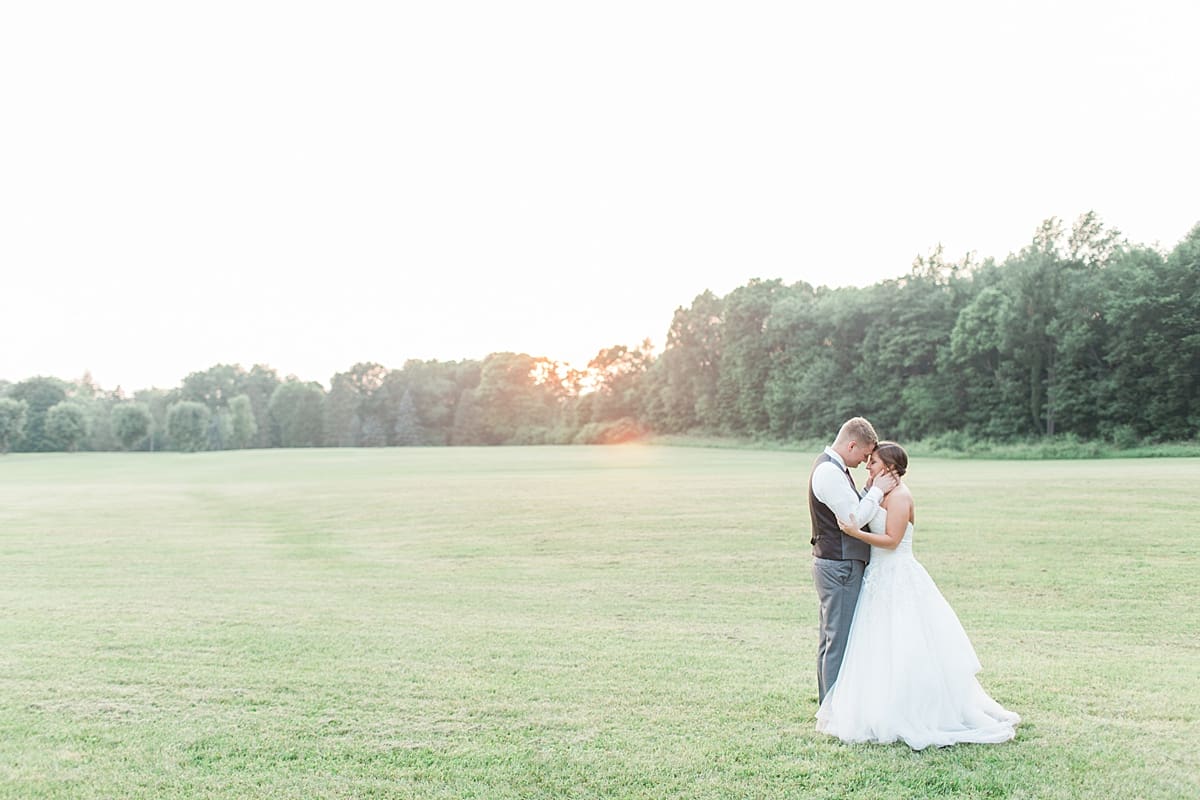 Arielle Peters Photography | Bride and groom almost kissing in open field on wedding day at Sts. Peter and Paul Social Hall in South Bend, Indiana.