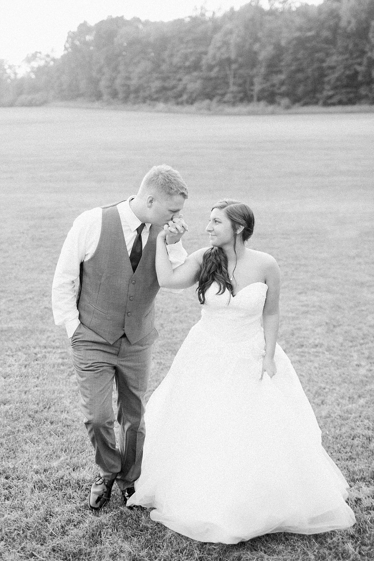 Arielle Peters Photography | Bride and groom holding hands in open field on wedding day at Sts. Peter and Paul Social Hall in South Bend, Indiana.
