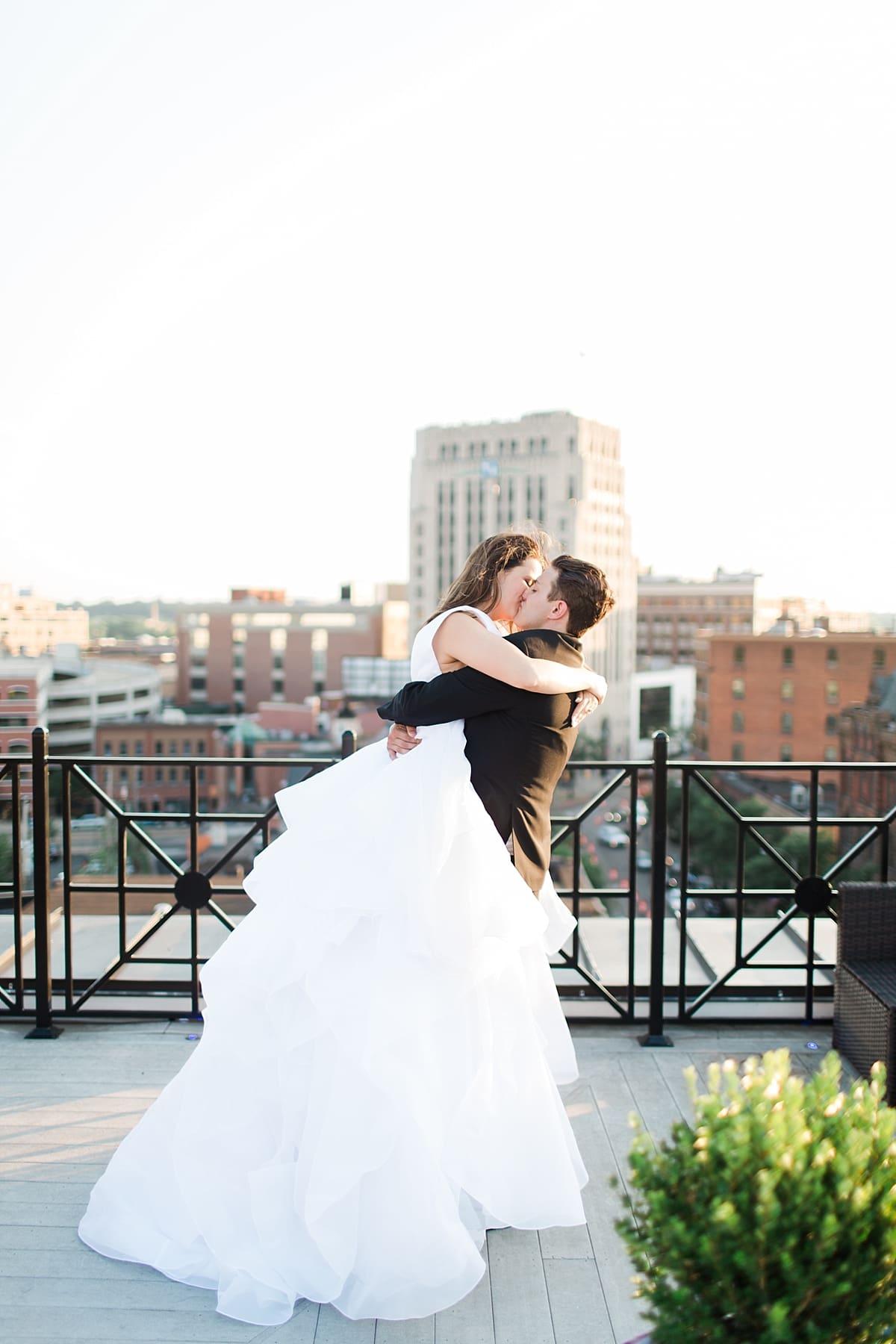 Arielle Peters Photography | Bride and groom kissing on rooftop terrace on wedding day at Loft 310 in Kalamazoo, Michigan.