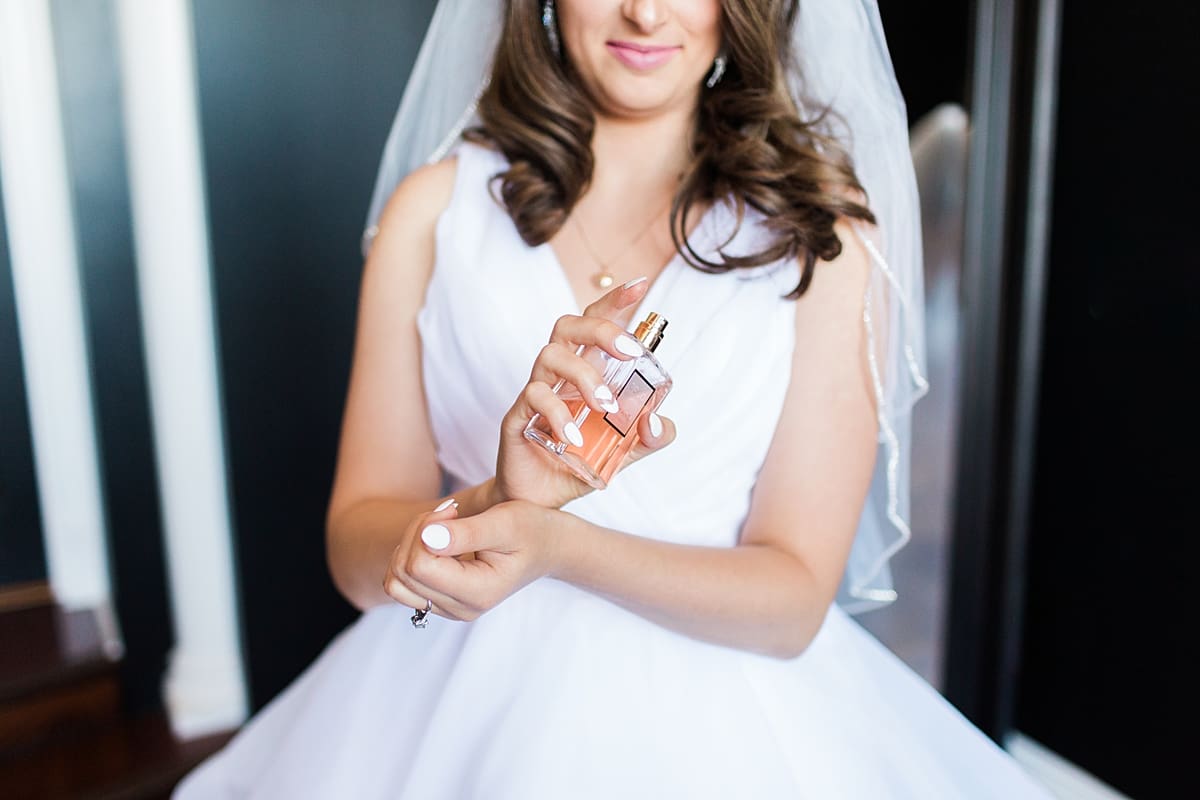 Arielle Peters Photography | Bride putting on wedding perfume on wedding day at Loft 310 in Kalamazoo, Michigan.