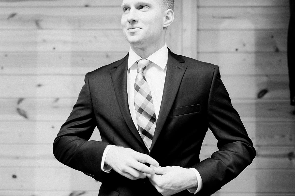 Arielle Peters Photography | Groom putting on tux jacket on wedding day at St. Joe Farm in Granger, Indiana.