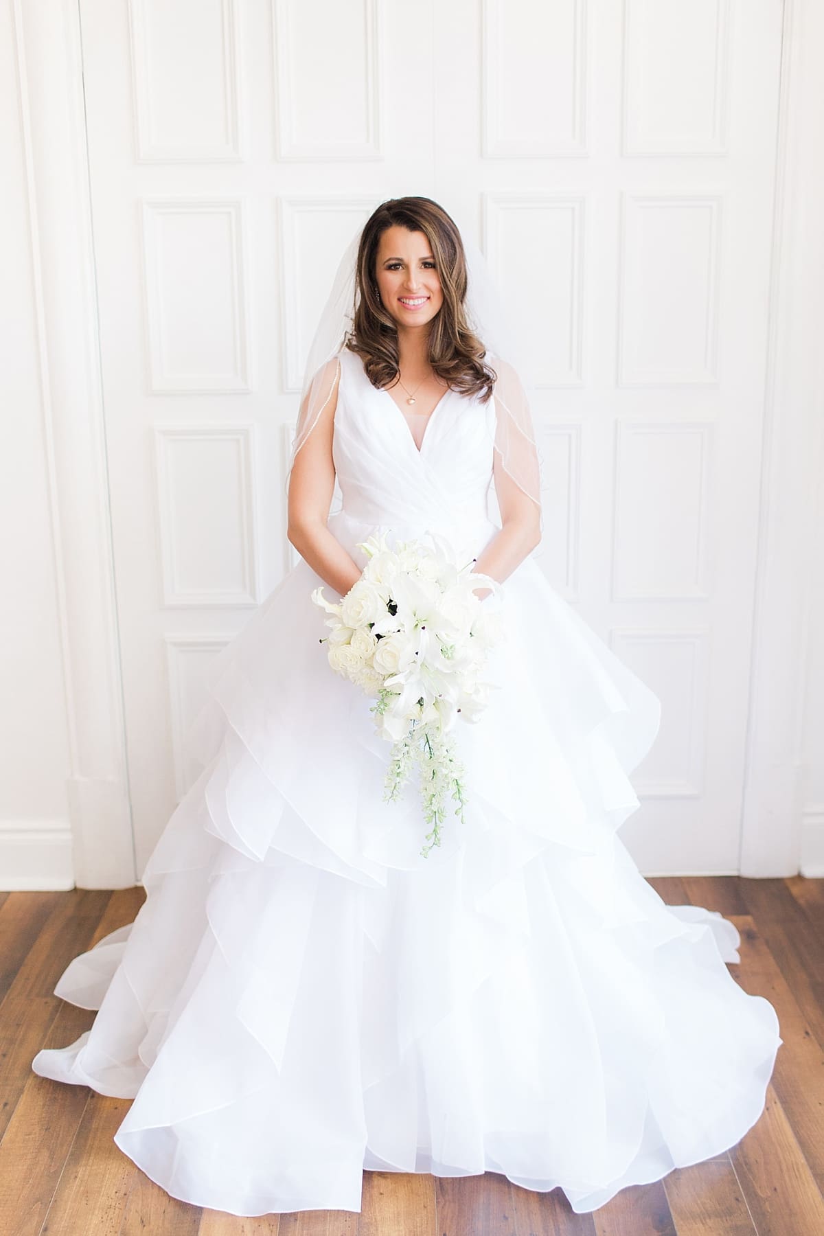 Arielle Peters Photography | Bride holding bouquet in front of french doors on wedding day at Loft 310 in Kalamazoo, Michigan.