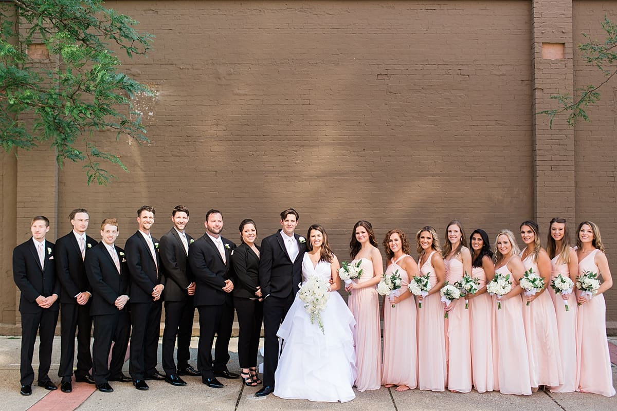 Arielle Peters Photography | Wedding party in front of brick wall on wedding day at Loft 310 in Kalamazoo, Michigan.